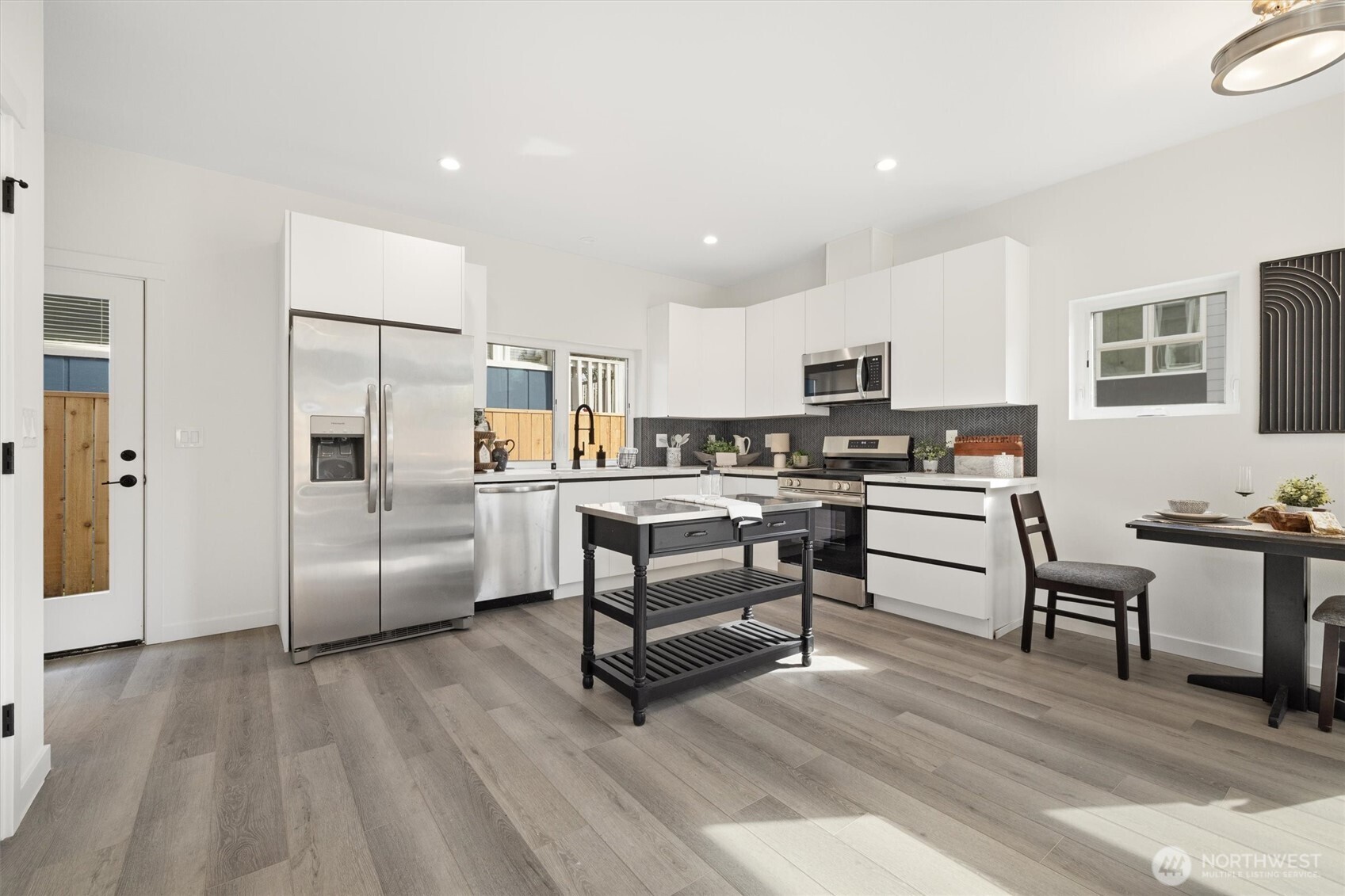 A chef-inspired kitchen boasts stainless steel appliances, flat-panel cabinetry, and direct access to the private patio for seamless indoor-outdoor living.