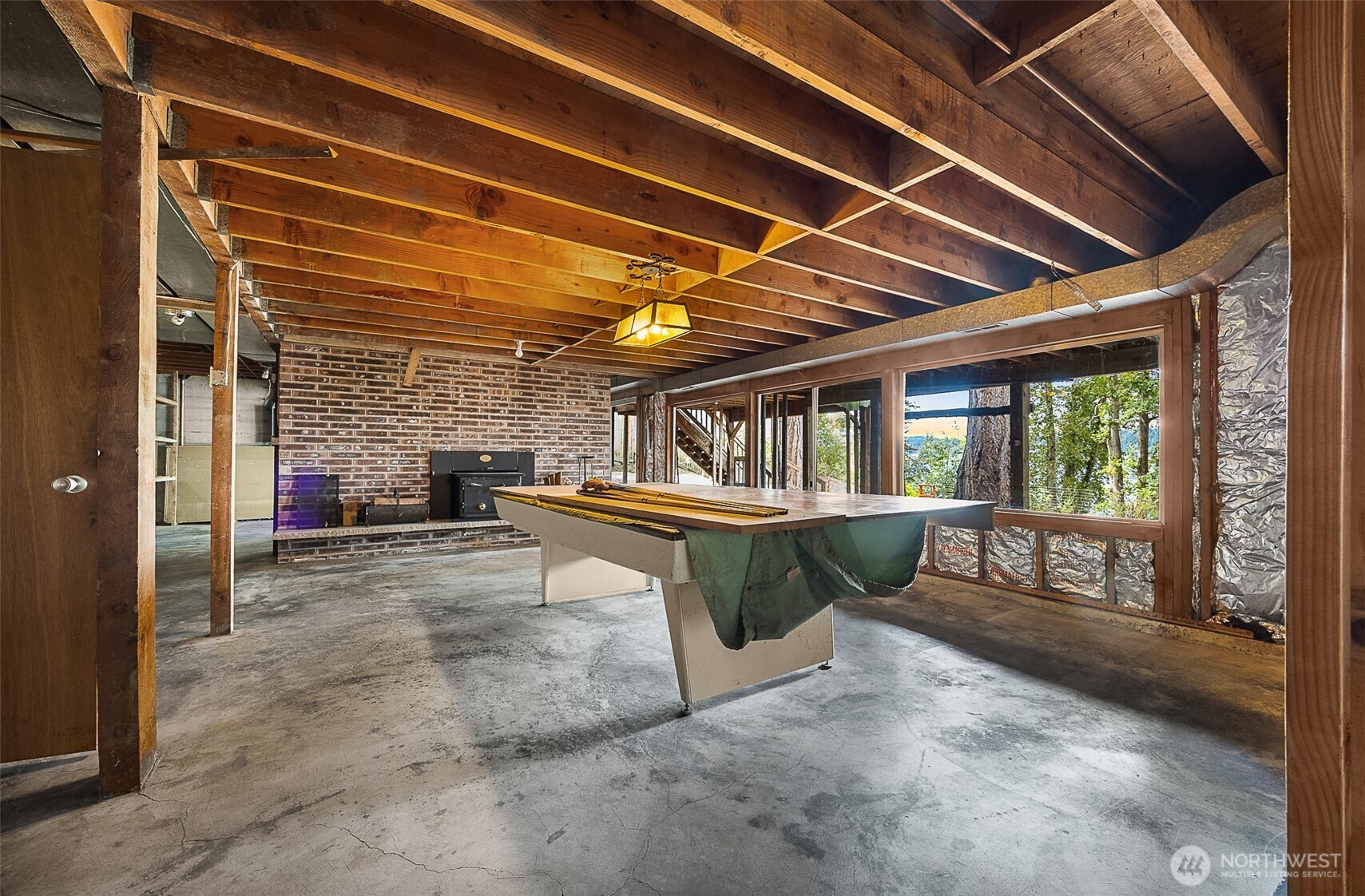 Unfinished space in basement used for the pool table.