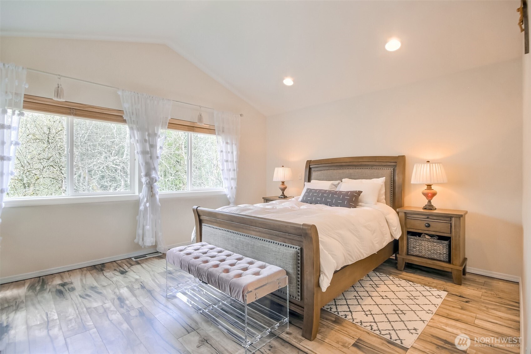 Primary suite has vaulted ceiling and wall of windows look out greenbelt area
