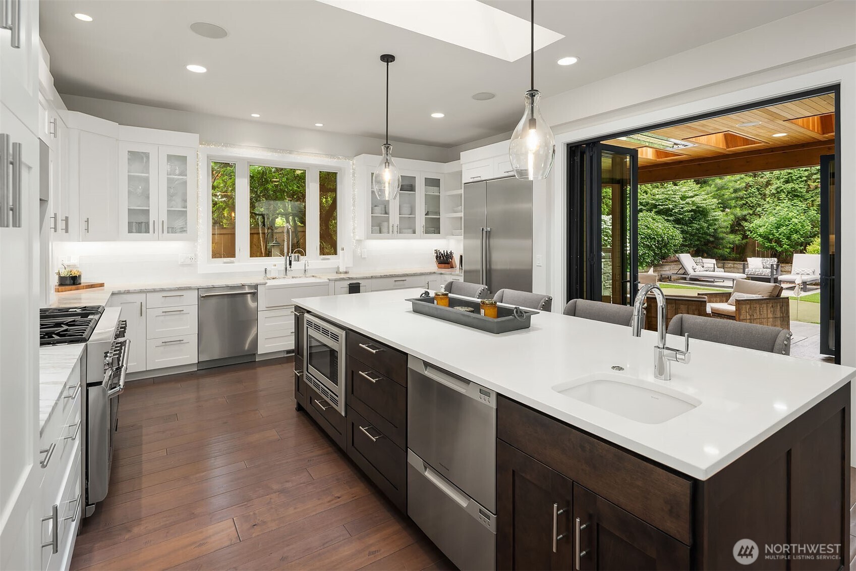 Brilliant white kitchen with shaker-style cabinets, quartzite counters and high-end appliances