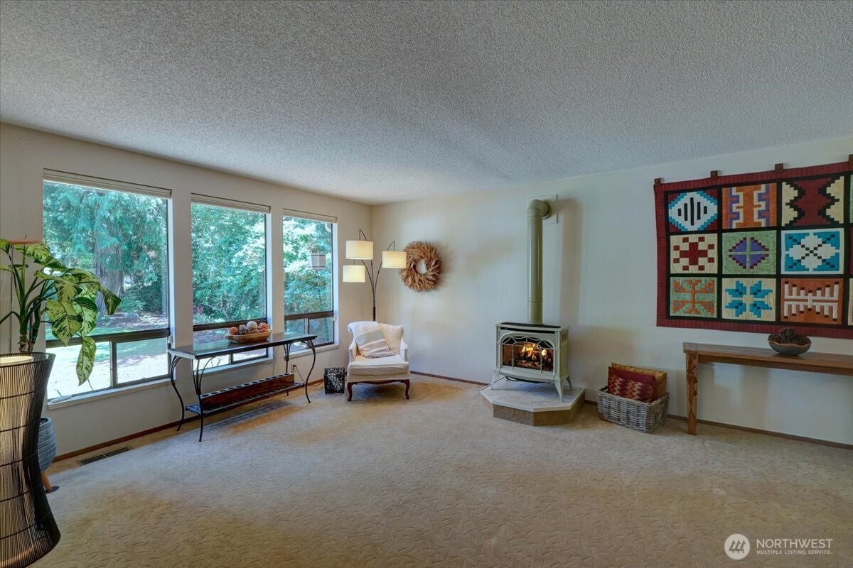Large spacious living room with free standing gas fireplace.