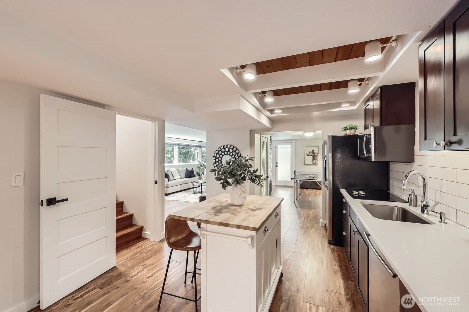 The door off the entry foyer makes the lower level versatile. Close the door to use the space as an ADU for rental income or in-law space. Keep it open for additional living space.