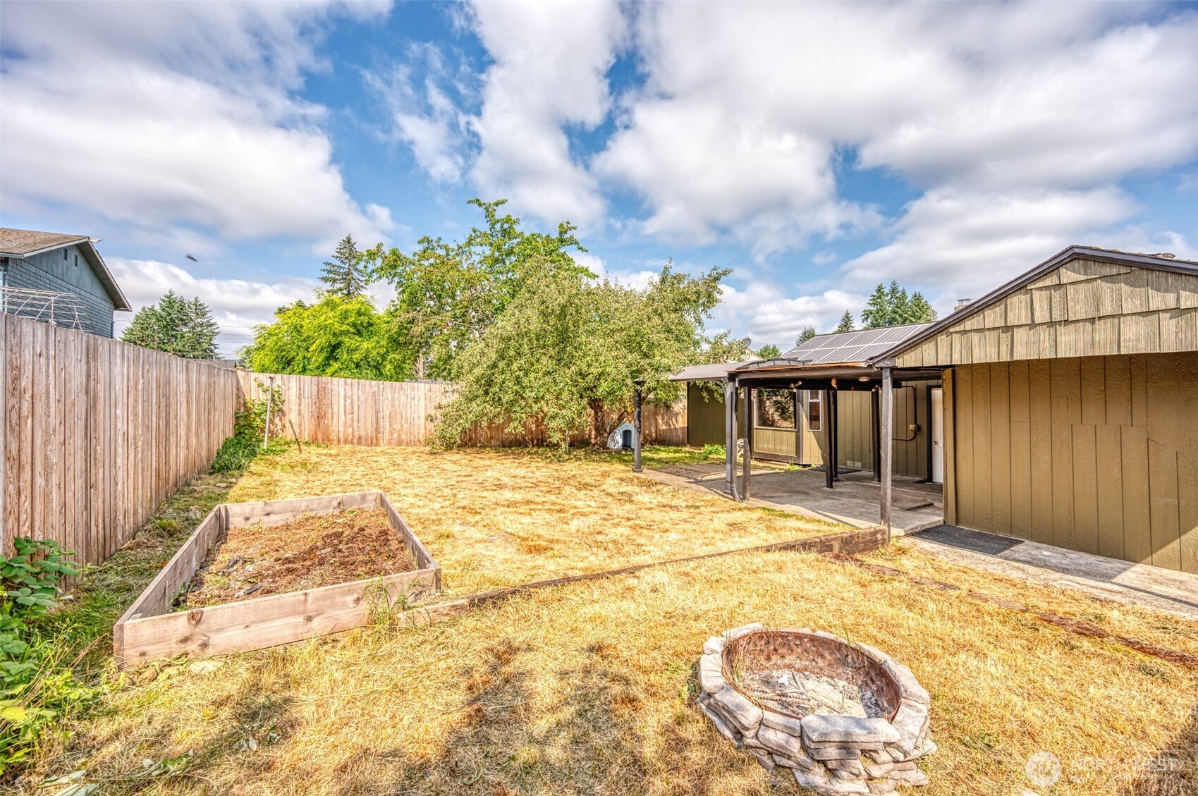 Rear yard is low maintenance but has garden box, firepit area, covered patio and a producing apple tree.