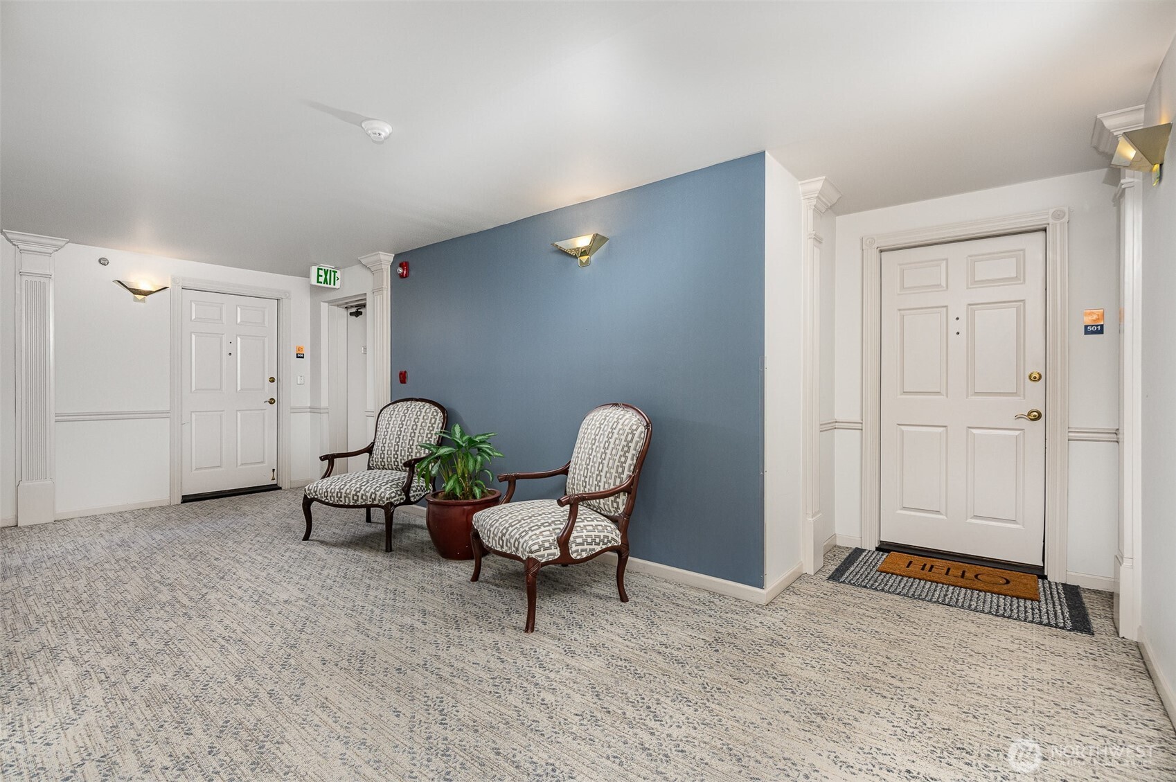 Unit 501 greets you with a private, peaceful corridor entrance—complete with classic trim, designer lighting, and a cozy seating nook just outside your door.