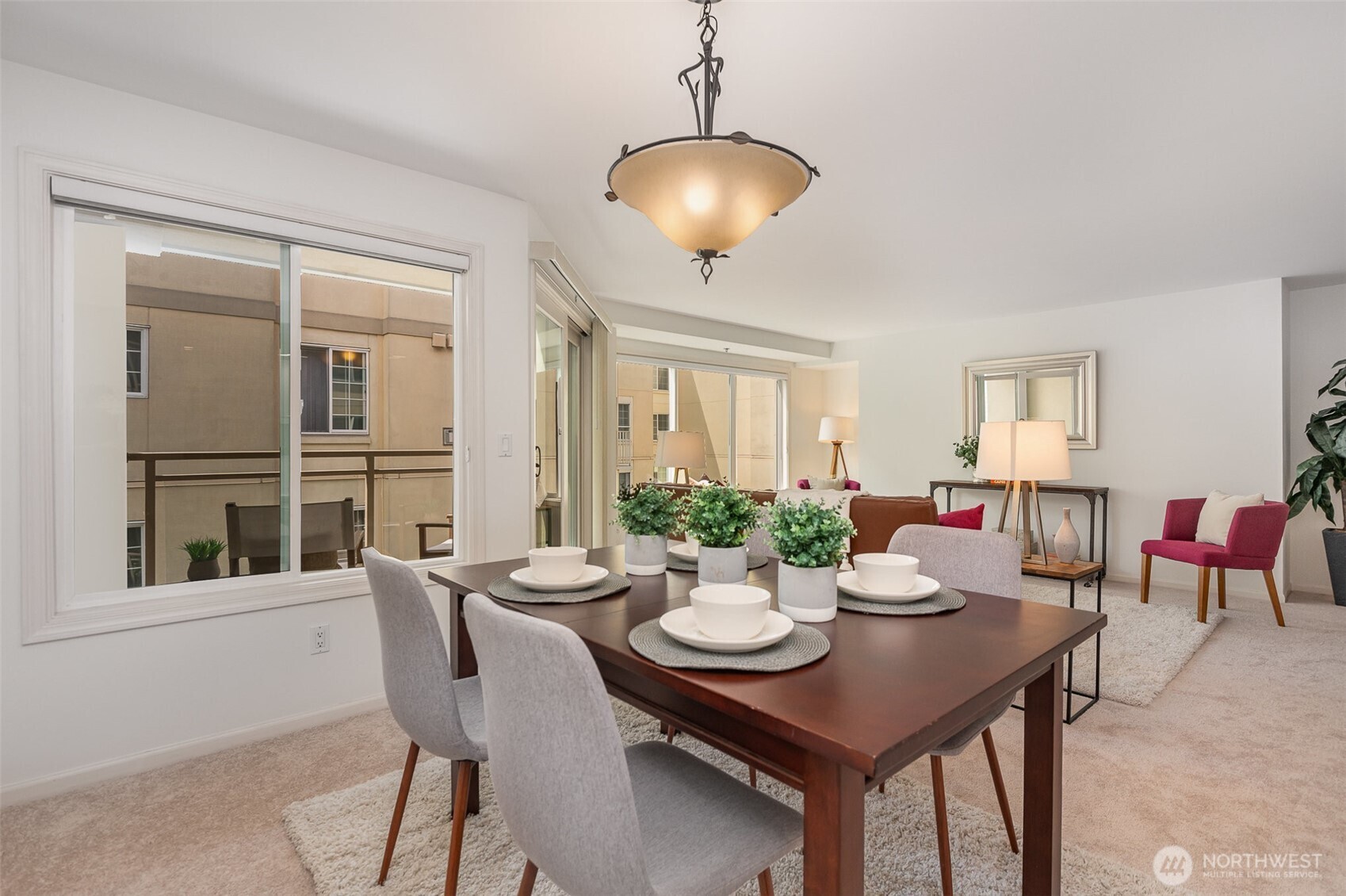 The dining area is bright and inviting, framed by large windows and a sliding glass door that opens to the private balcony—perfect for entertaining.