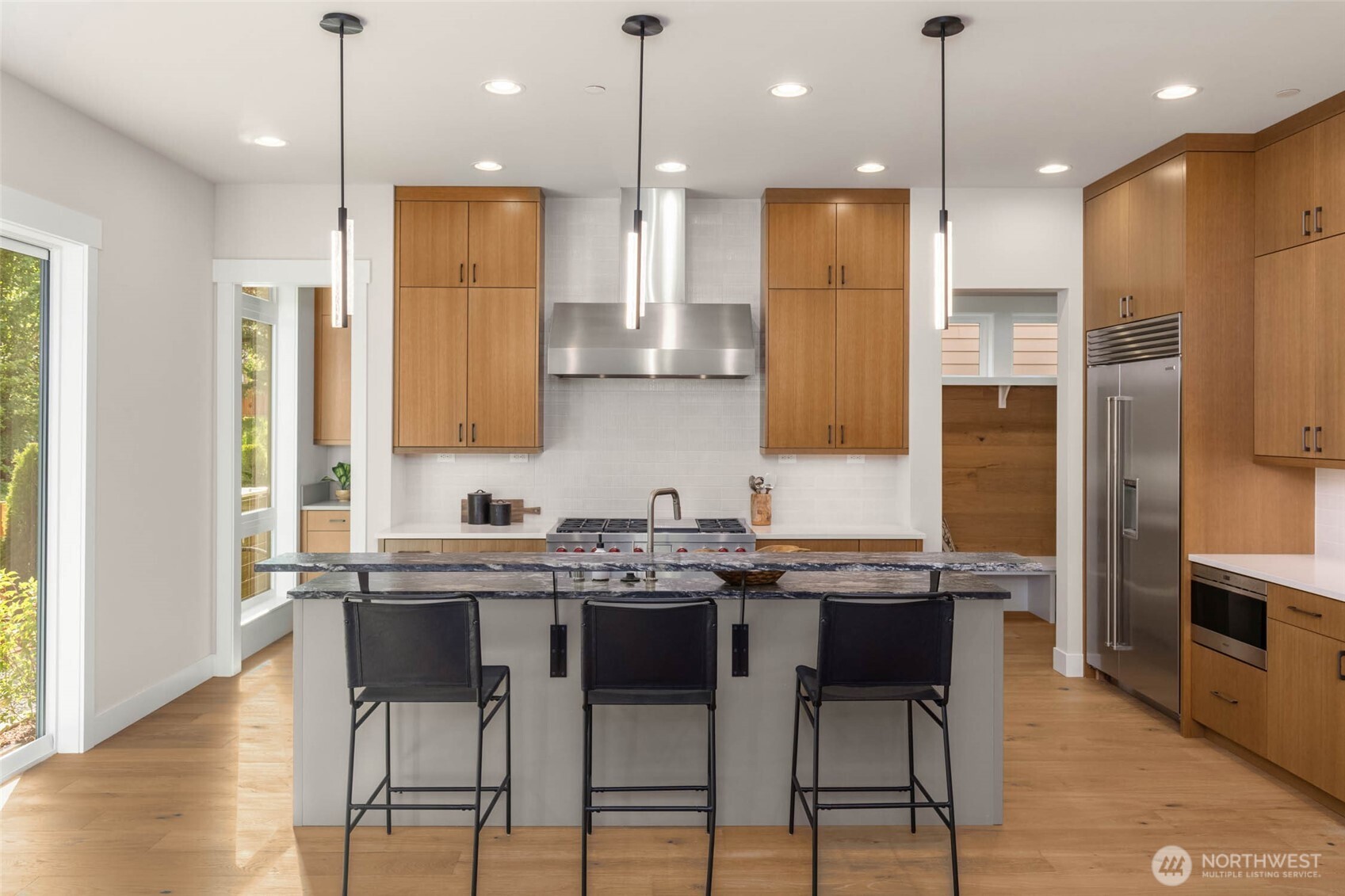 Kitchen features custom built rift oak cabinets, full height designer backsplash and is conveniently connected to the mud room and thoughtfully designed prep pantry