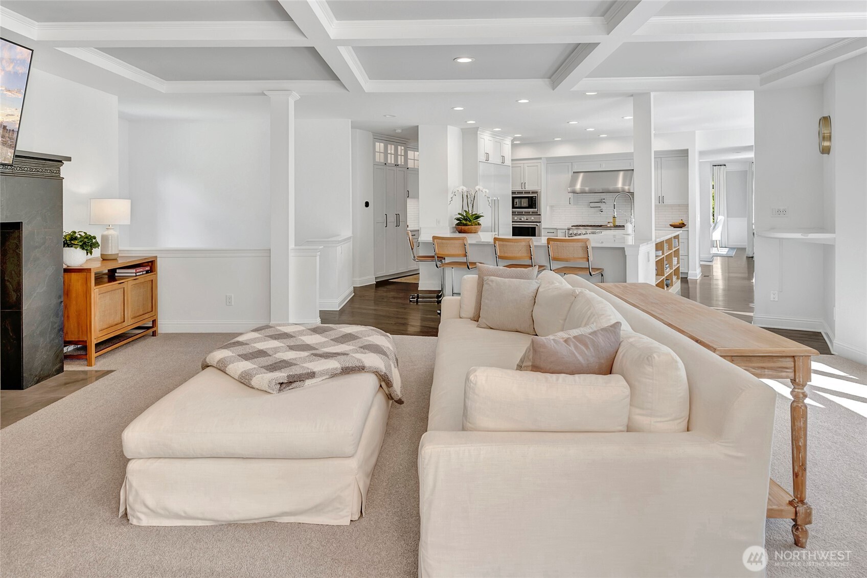 The open floor plan provides ample space leading from the kitchen to the family room, with beautiful box beam ceilings, dramatic gas fireplace and French doors out to the fully covered deck.