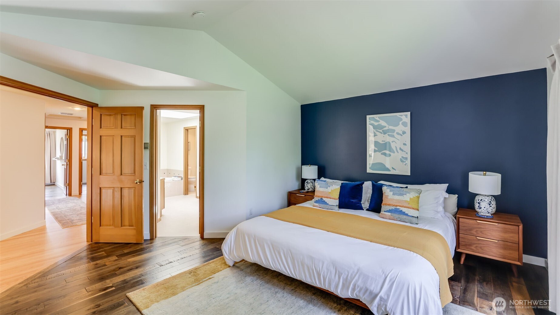 Enter the primary suite through elegant double doors onto rich, dark hardwood flooring. This retreat boasts an attached five-piece en-suite bathroom, combining luxury and comfort seamlessly