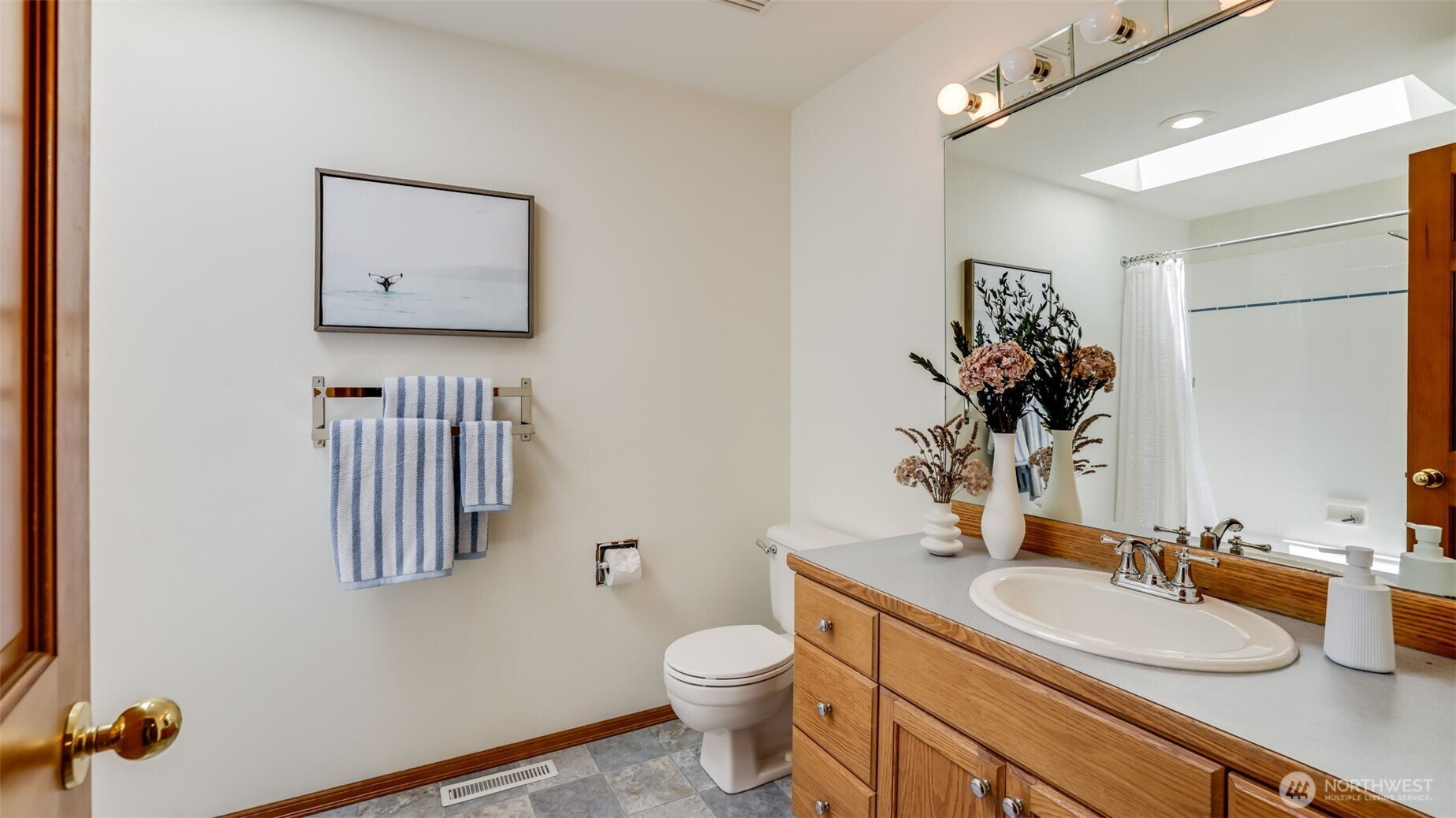 This full guest bathroom features durable vinyl flooring and a convenient shower/tub combo—ideal for both comfort and functionality