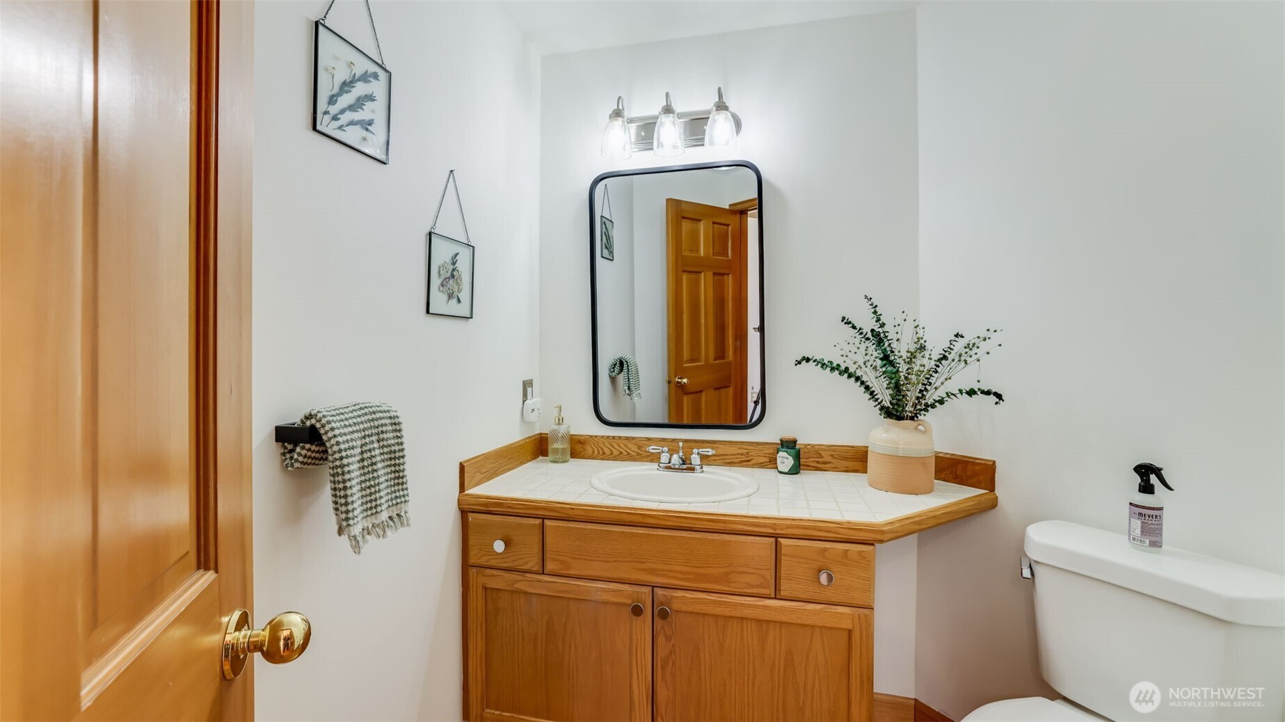 Chic and functional guest 1/2 featuring a stylish mirror above the sink and ample storage space, perfect for everyday use