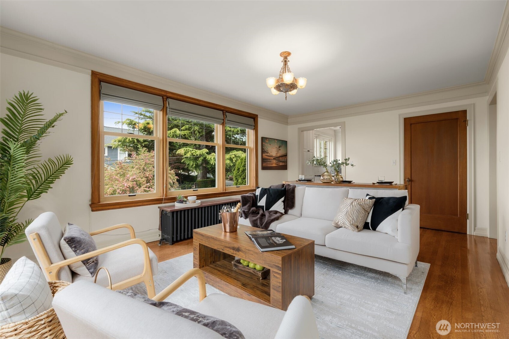 Living Room with Large West Facing Windows and a Large Walk-In Storage Closet, with the Kitchen Entrance beyond.