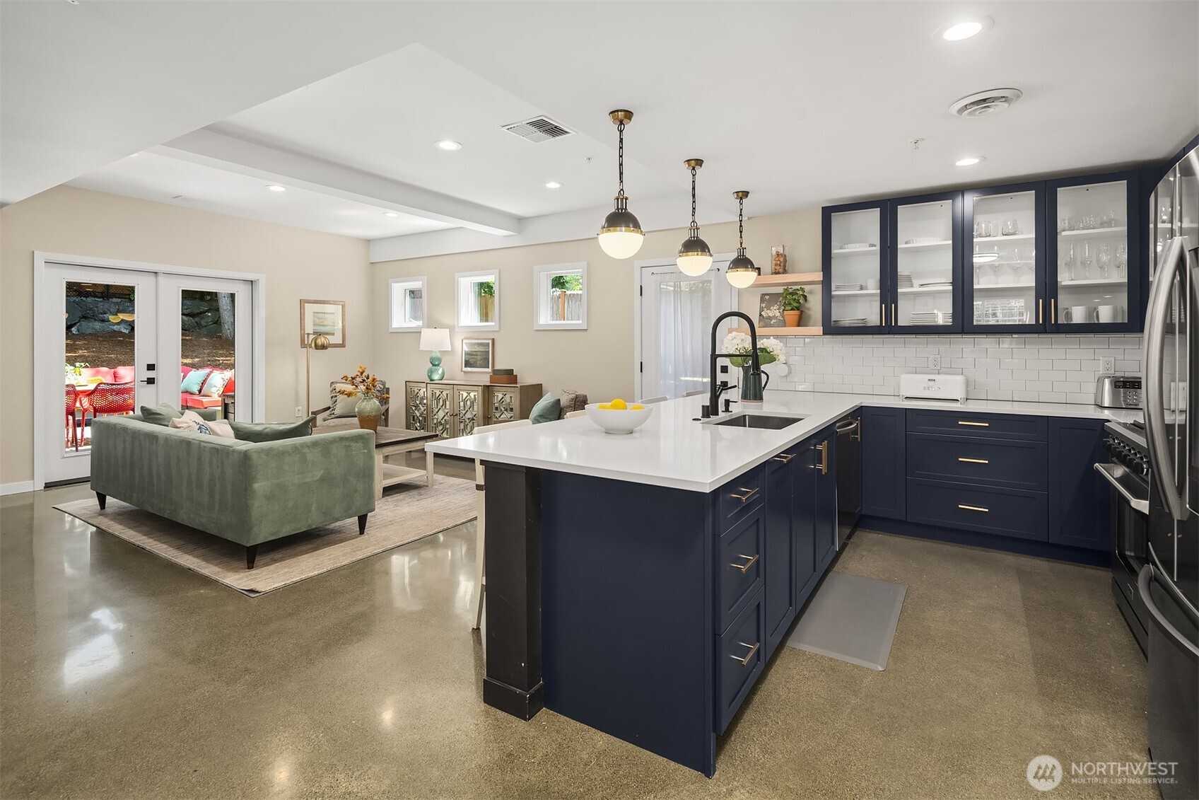 A cohesive open-concept kitchen with luxury finishes and fluid connection to the great room and backyard through double French doors.
