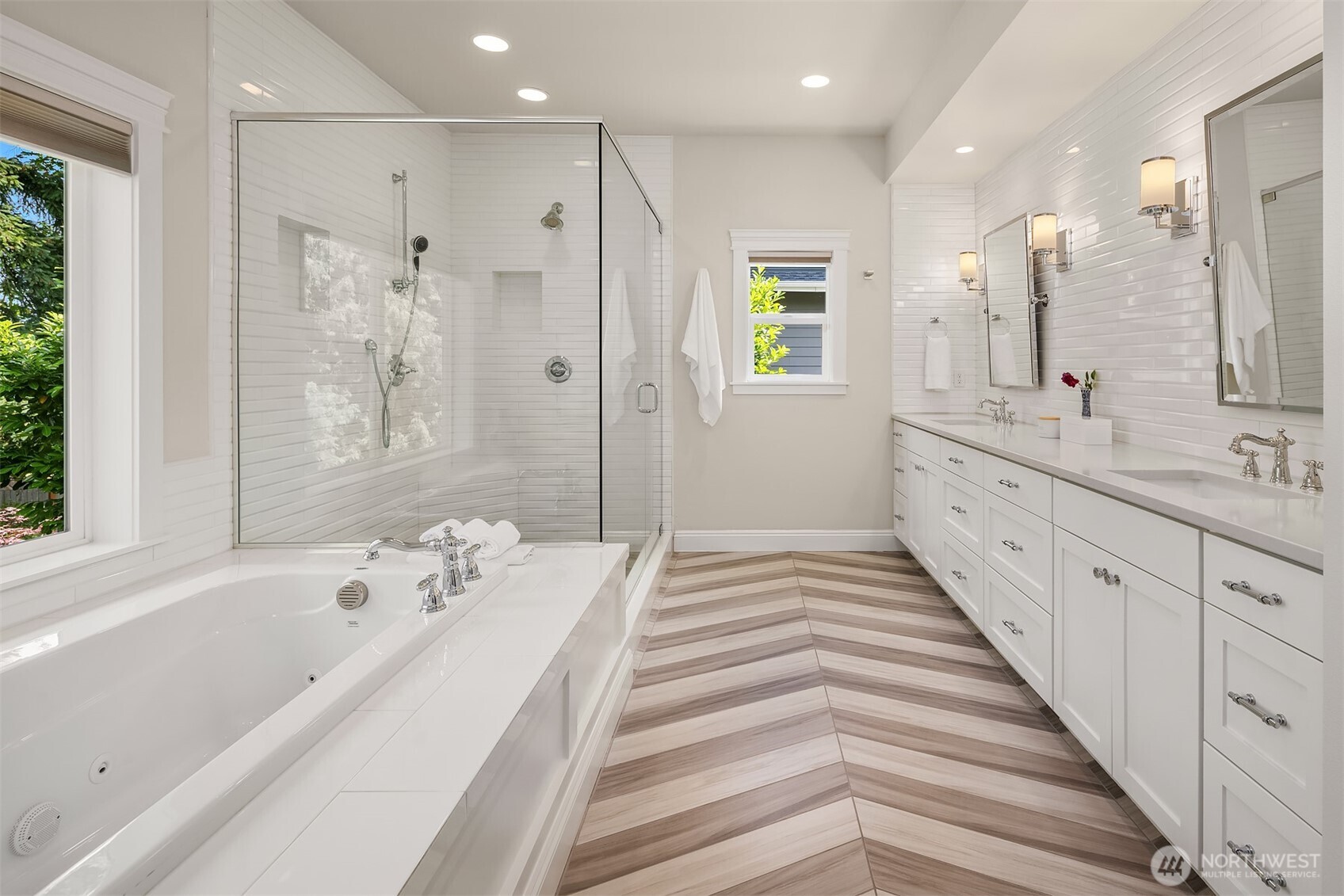 Chevron floors, dual vanities, and a soaking tub with a garden view—this spa-like bath checks every box on your “treat yourself” list.