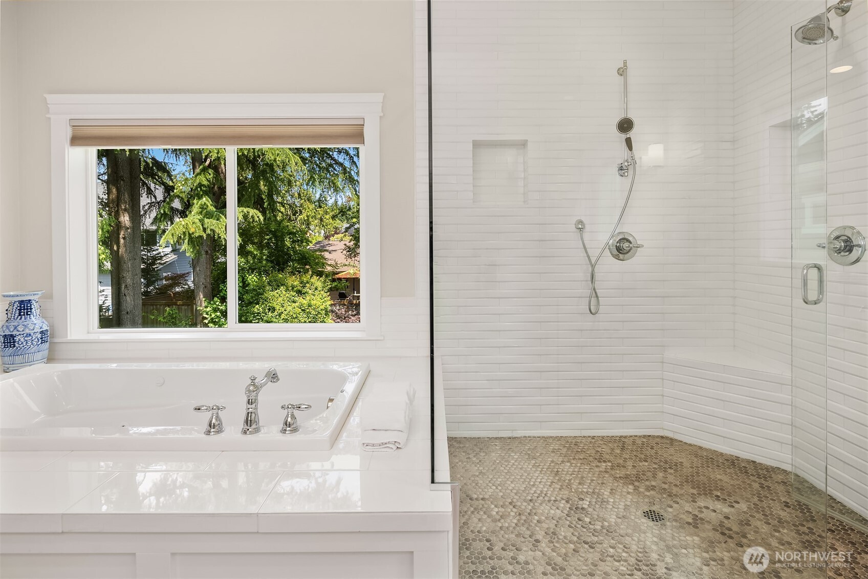 Room for two and views for days—this spa-inspired tub and luxe dual-shower combo is where stress goes to retire.