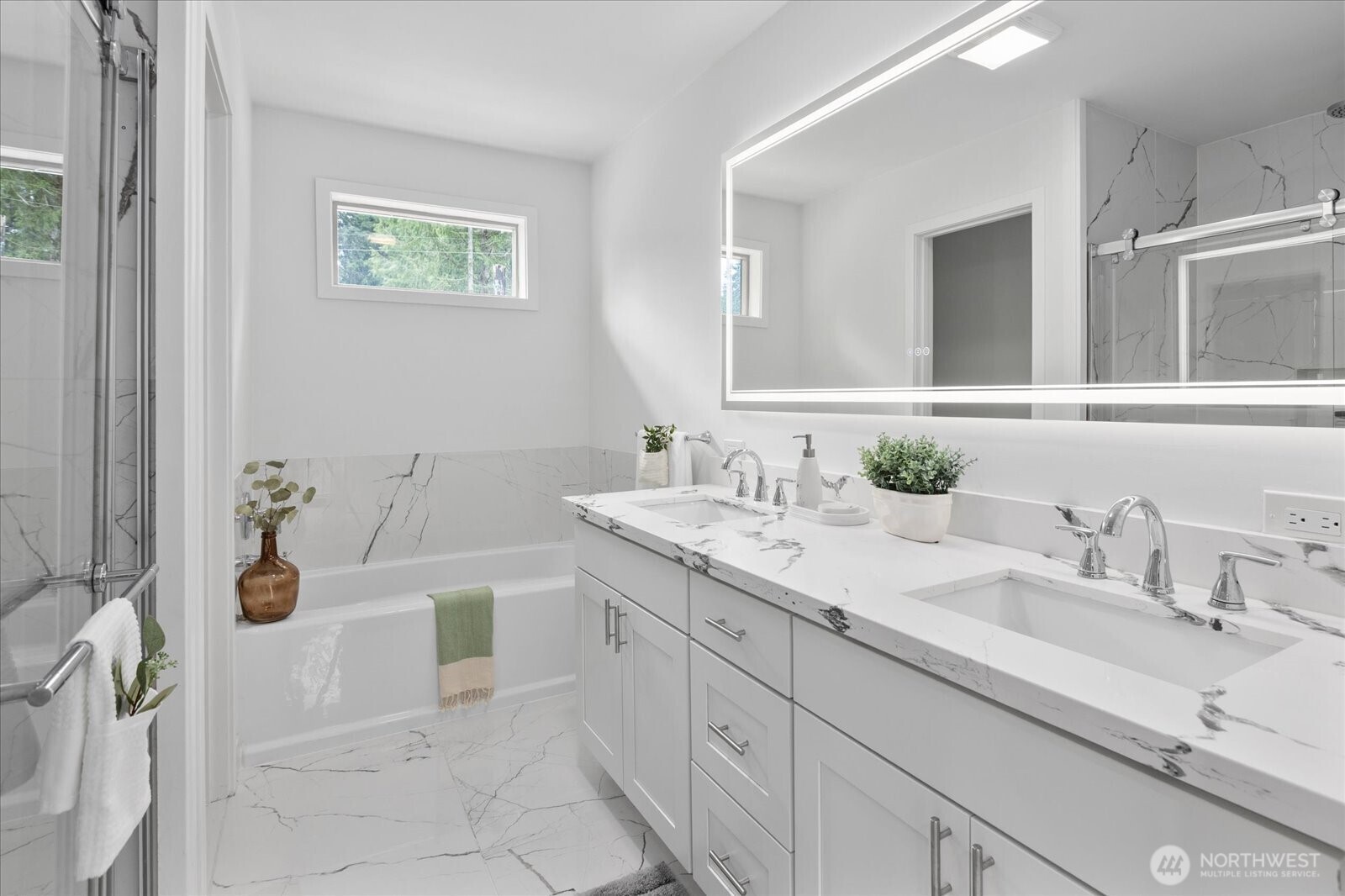 Spa like bathroom in the primary bedroom, with custom tile, quartz counters and LED mirror.
