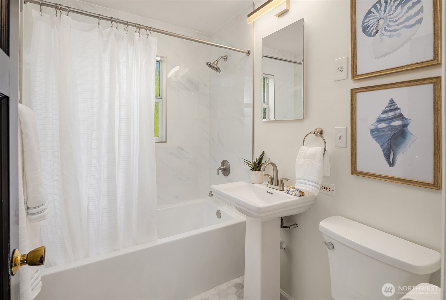 Main floor bathroom with octagon tiled floors and a pedestal sink.