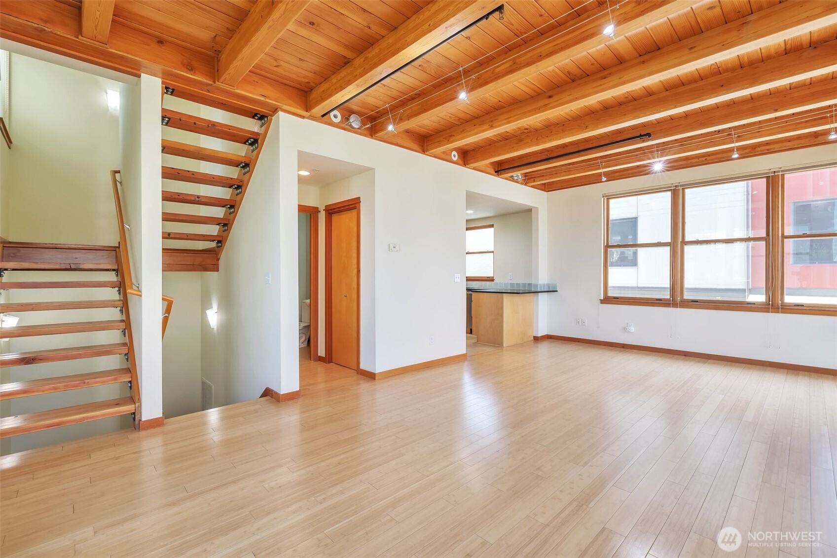 Light-filled and airy interior design with spacious living areas. Beautiful exposed wood beam ceiling and open, reclaimed wood staircase.