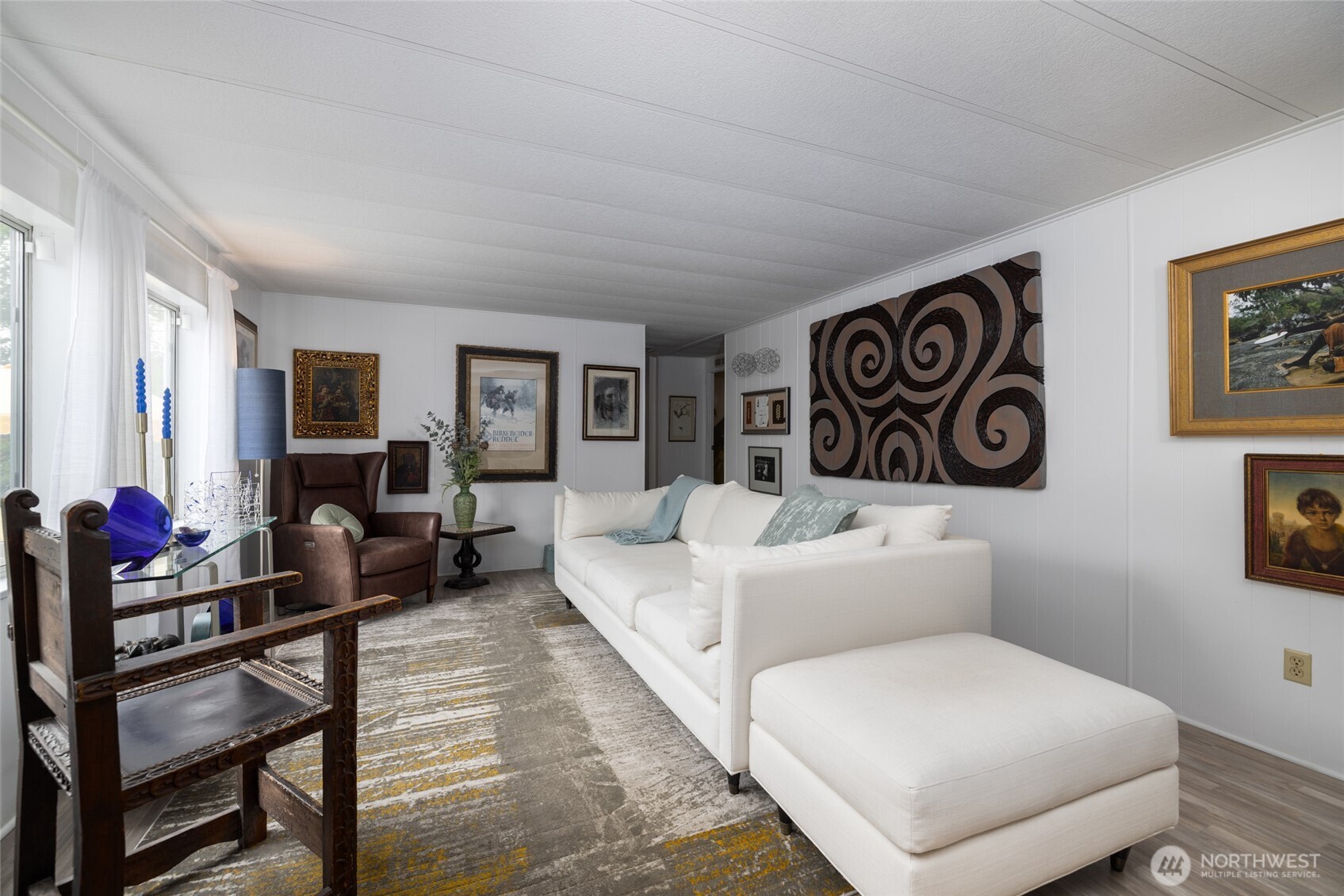 Fresh white paint and large windows create a welcoming, light-filled front room.