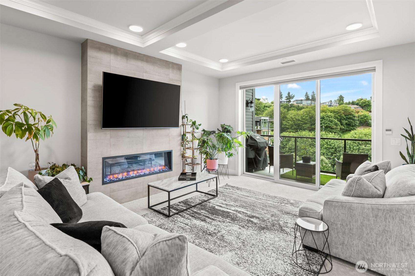 Spacious living/great room with a coffered ceiling detail and access to your deck.