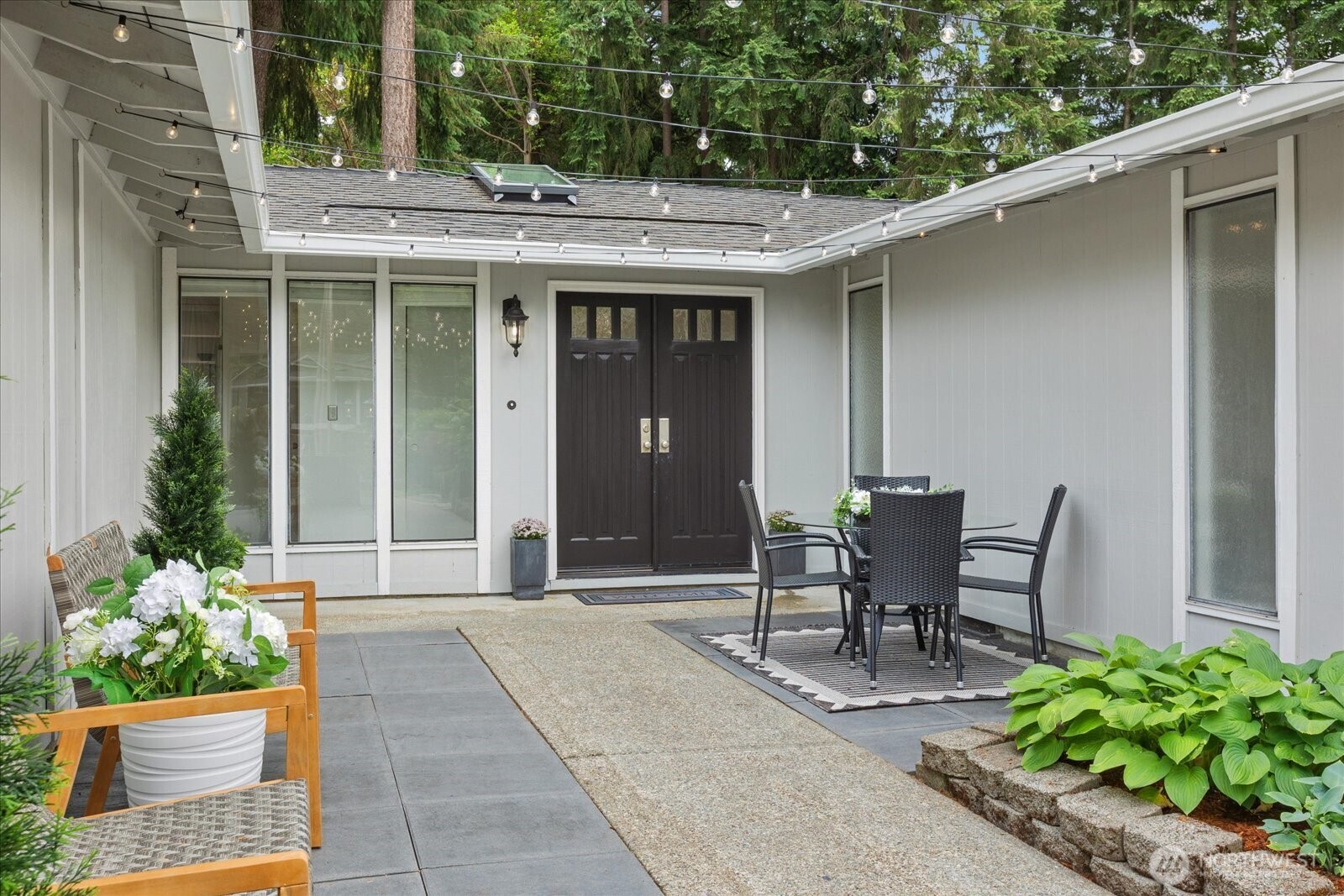 Double doors open to the home at the end of the wide courtyard.