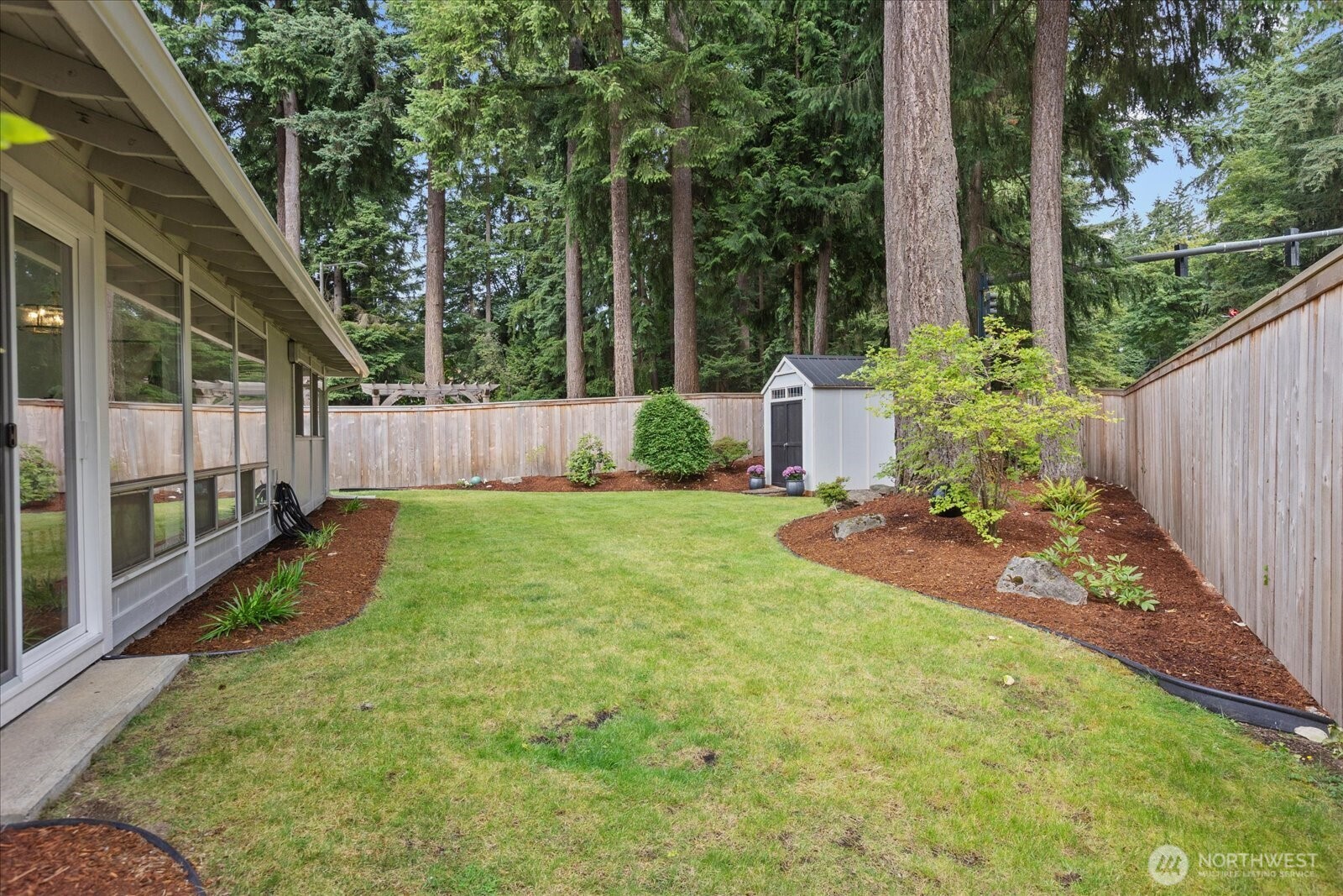 Back yard with a glimpse of the living room patio door on the left.