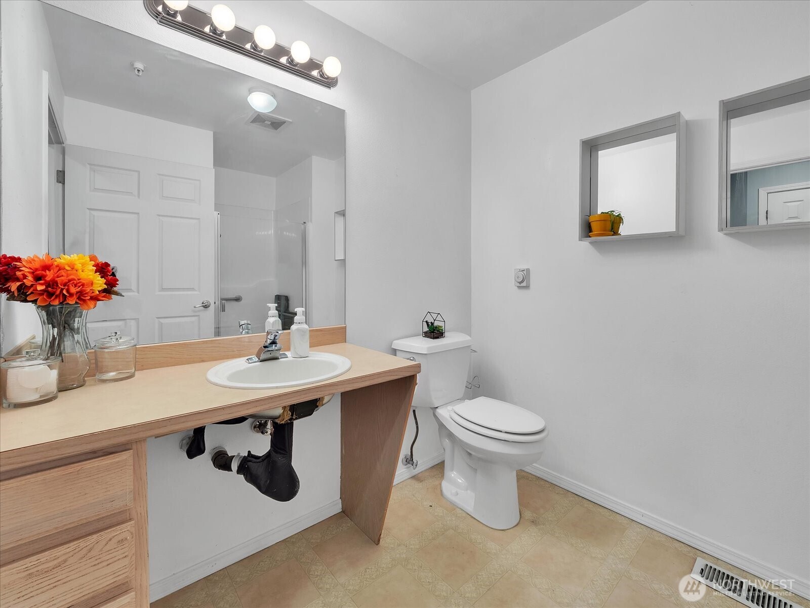 Secondary bathroom in wide hallway with roll under vanity.