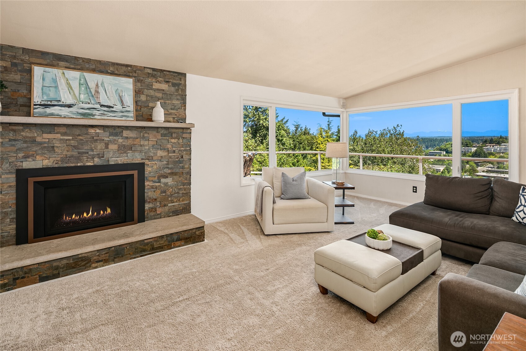 This living room continues to take in the views and during colder months you can cozy up to the beautiful stone mantel and fireplace.