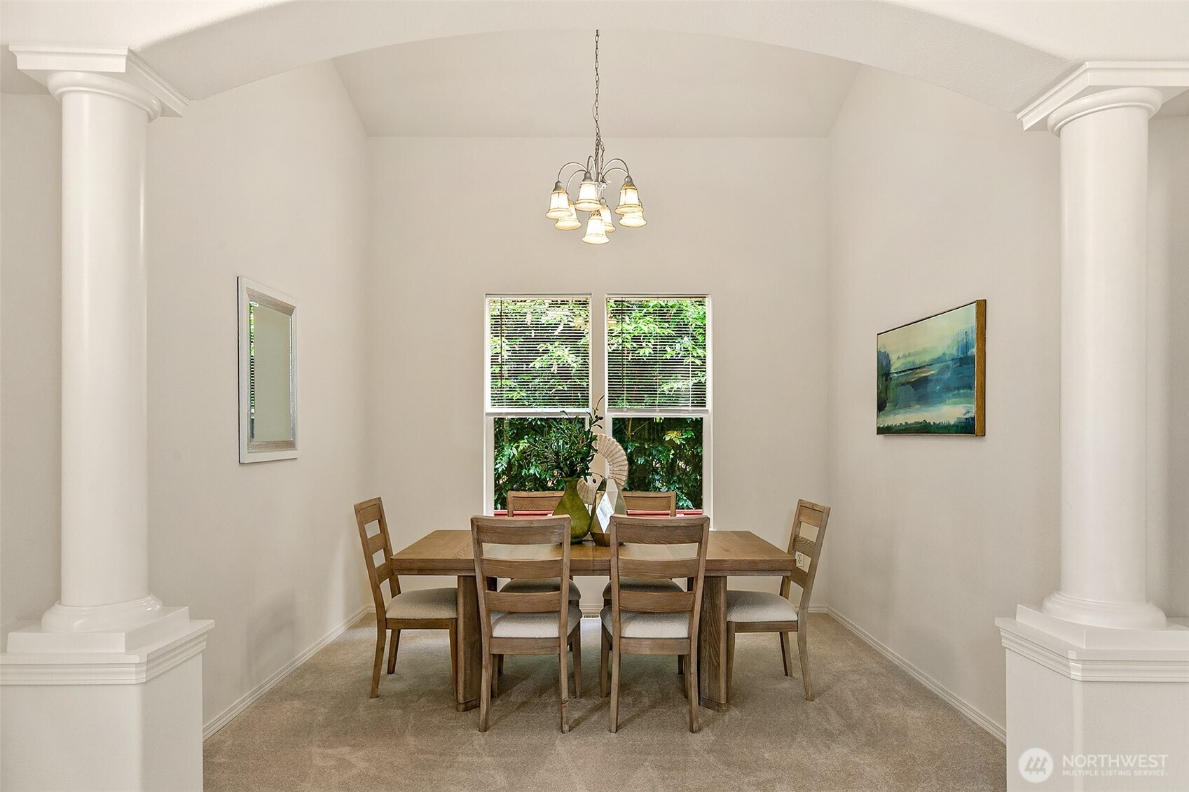 Formal dining room flanked by dramatic columns.