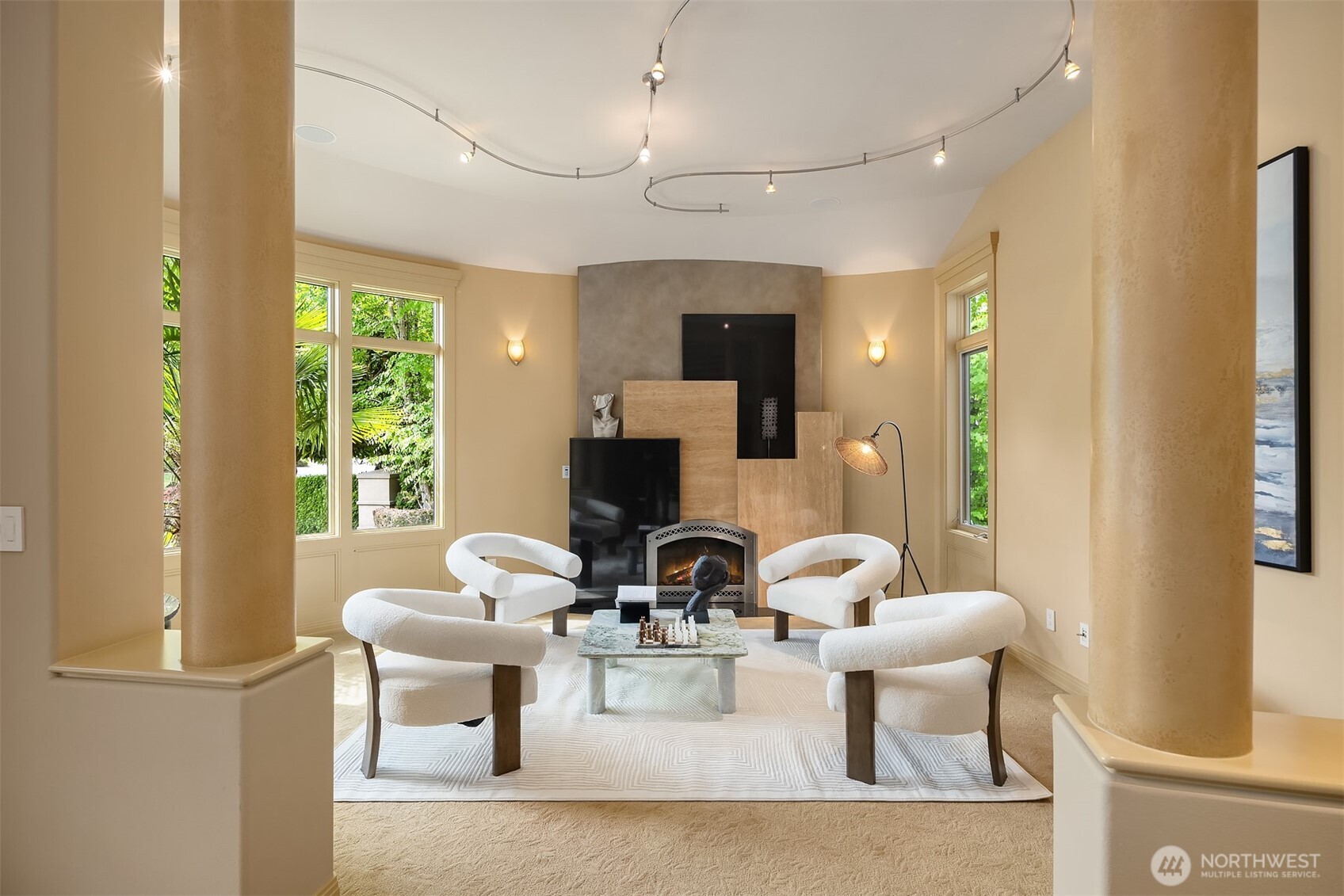 Formal living room is anchored by architectural gas fireplace and wet bar with sink and bev fridge just off to the left