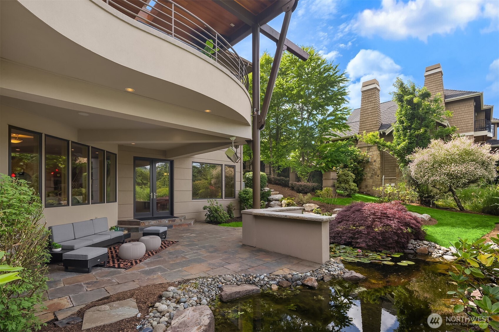 Step out from lower level to covered patio, built-in seating bar and water feature. Off to the left out of the photo is an outdoor room wired for you spa!
