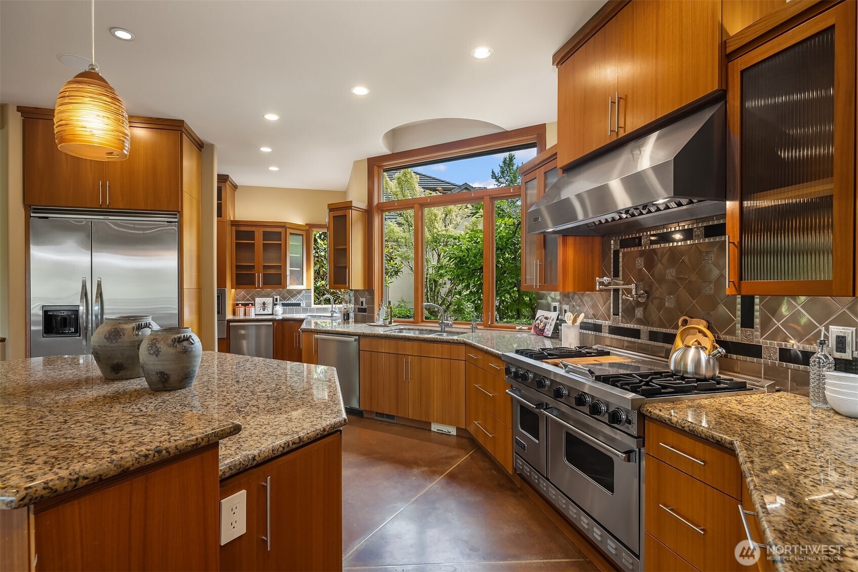 Full view of gourmet kitchen with slab granite counters, tiled backsplash, pot filler, under & over cabinet lighting