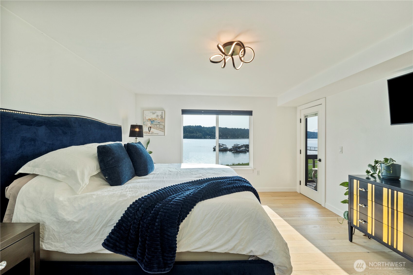 Primary bedroom with multiple views out of the window and deck door