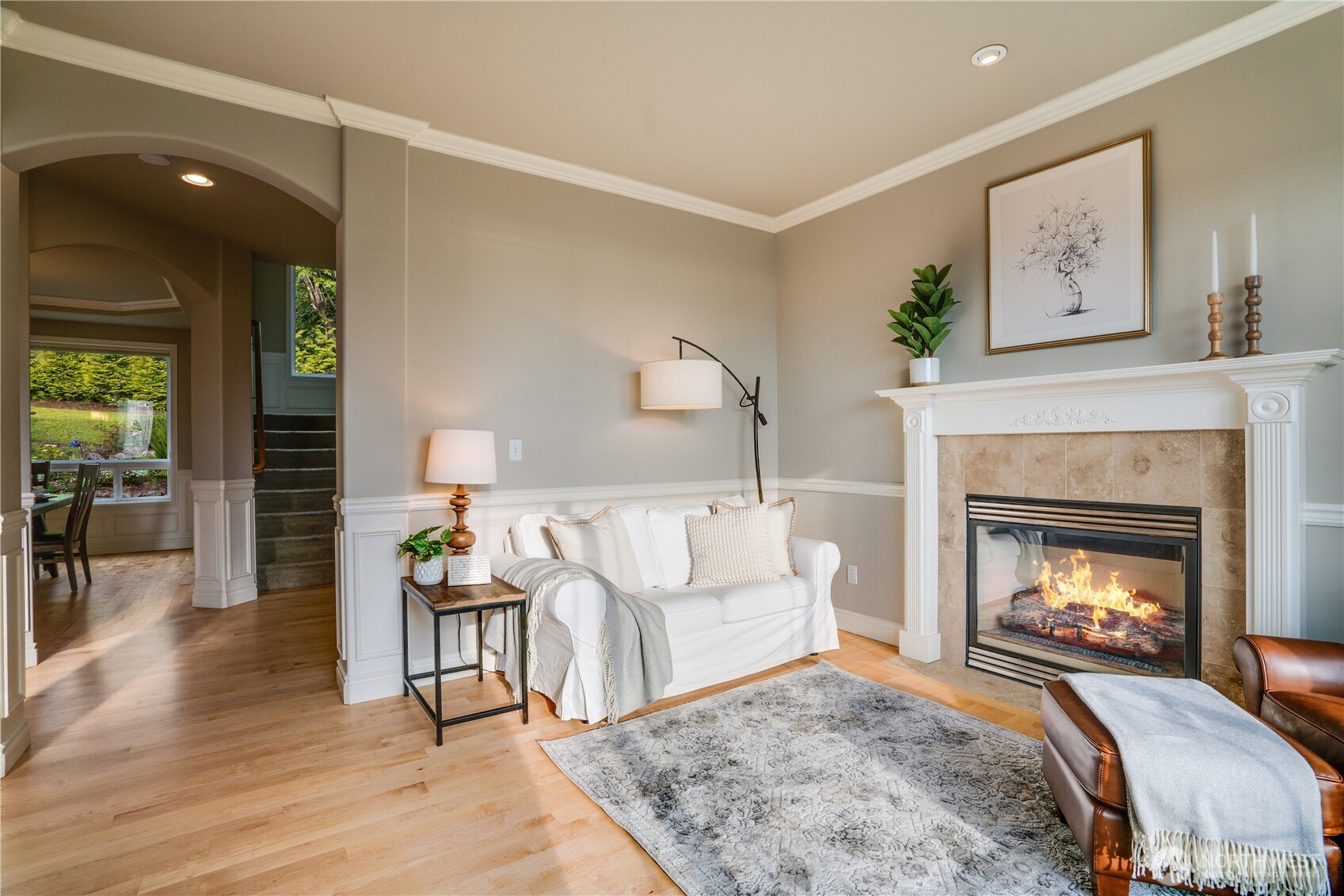 Second view of the living room.  Arched openings, hardwood floors, crown molding and wainscoting details.