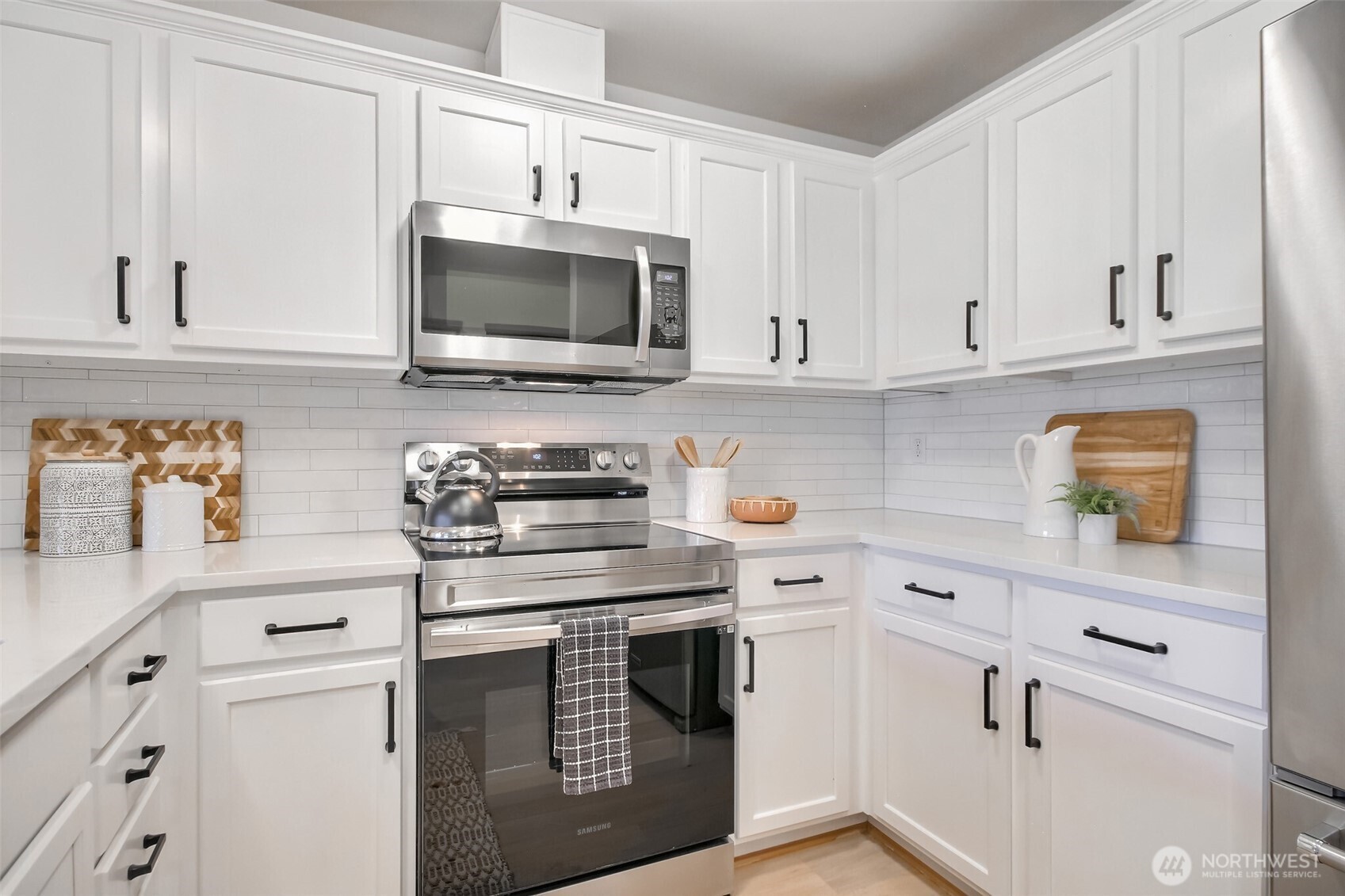 Updated kitchen with newer appliances, white cabinets and quartz countertops