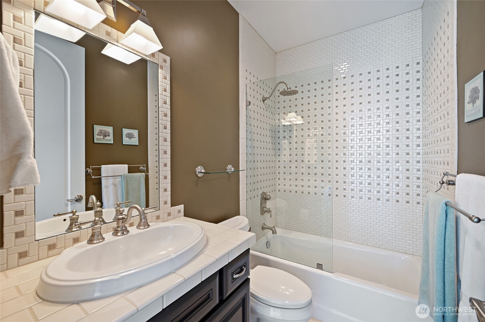 The tile work throughout the home is spectacular. This room features Pental Astor Deco Brick-A-Linen tile combined with Sierra Madre. The owners installed the partial glass wall so you see the beautiful tile.