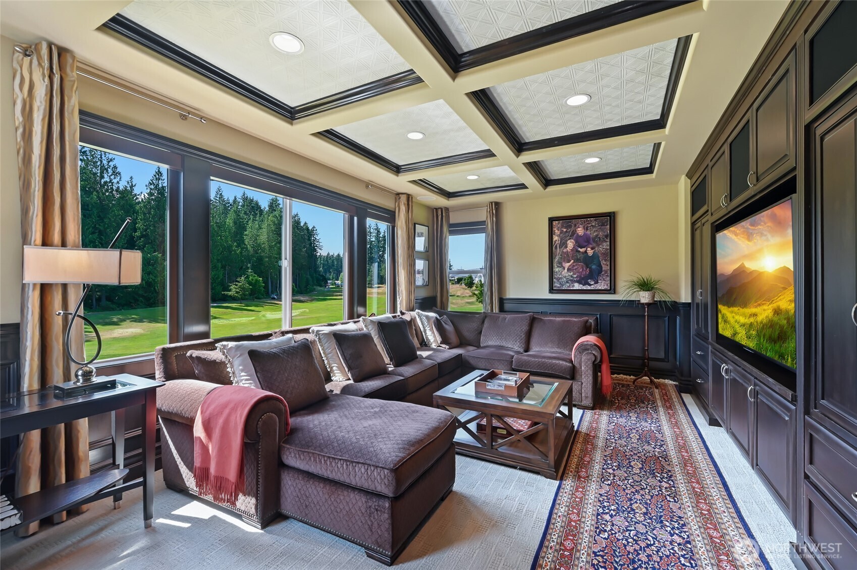 Upstairs is the handsome media room with rich wood cabinetry and wainscoting set off by another tin coffered ceiling. How easy would it be to while away the hours just looking at this view?