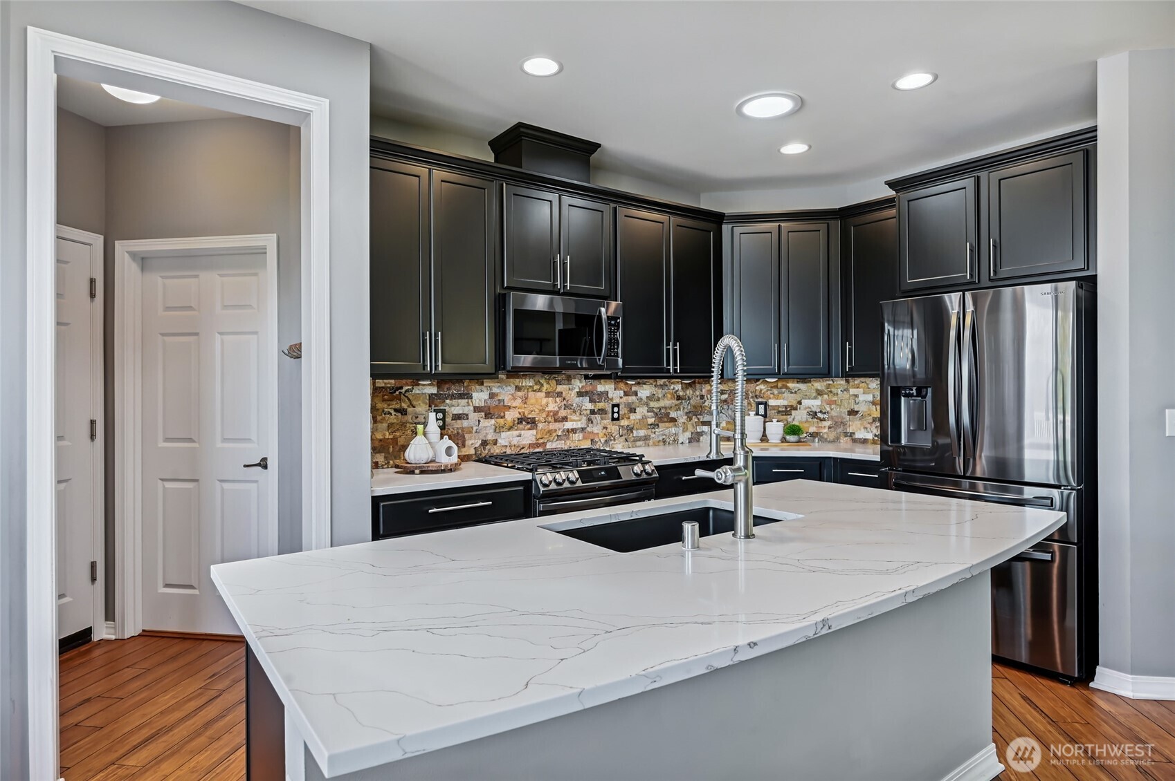 All new appliances since 2020, sleek black cabinets set off with stainless handles and the stone backsplash matches the fireplace.