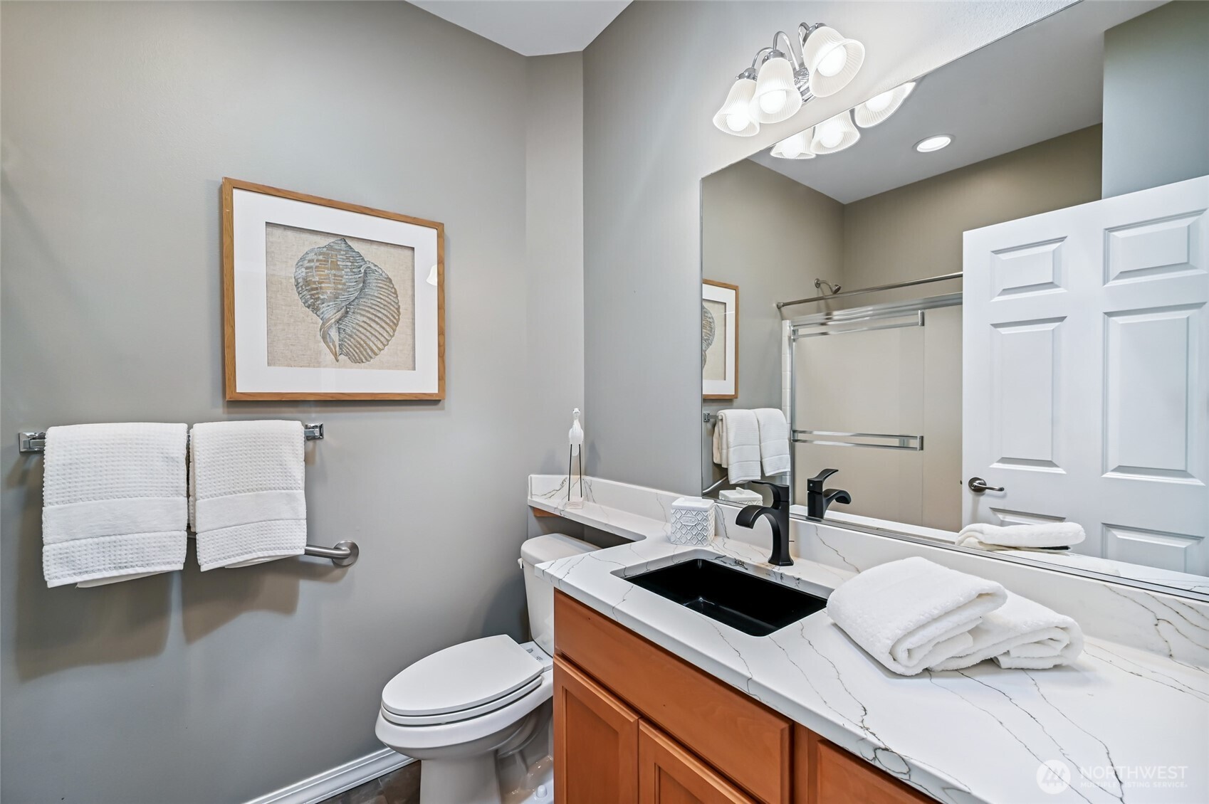 The full bath is right next to the second bedroom and also has a quartz counter, undermount sink, and new faucet. Porcelain tile flooring.