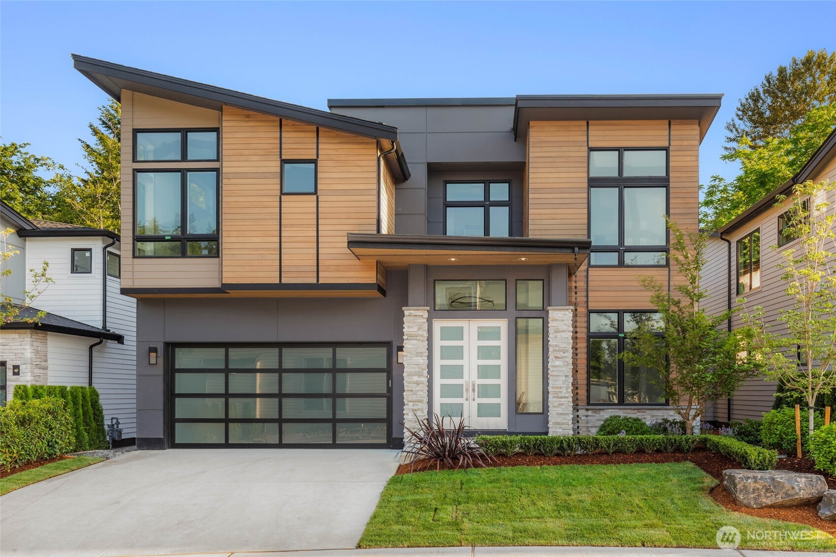Extensive use of clear cedar siding, professionally designed landscaping with full yard irrigation, contemporary glass garage door
