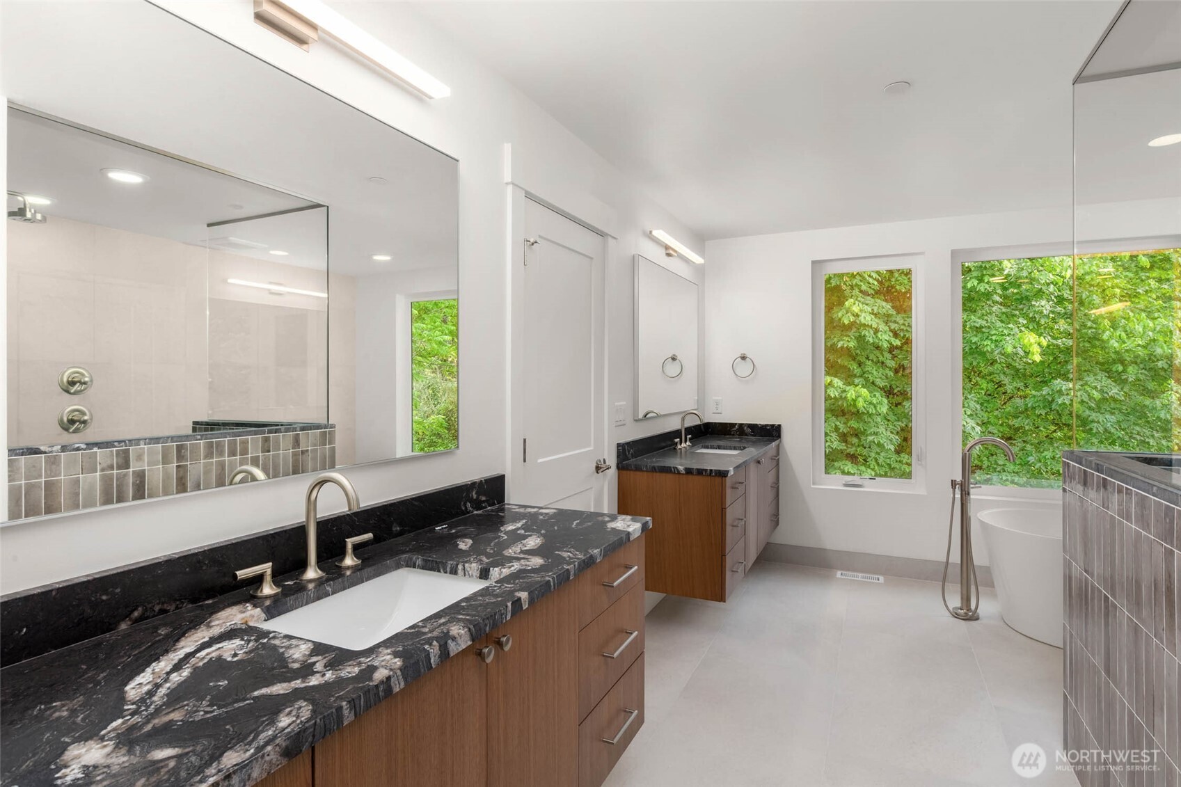 Expansive primary bath features duel custom floating vanities, free standing soaking tub, heated tile floors and frameless glass enclosed shower with duel heads