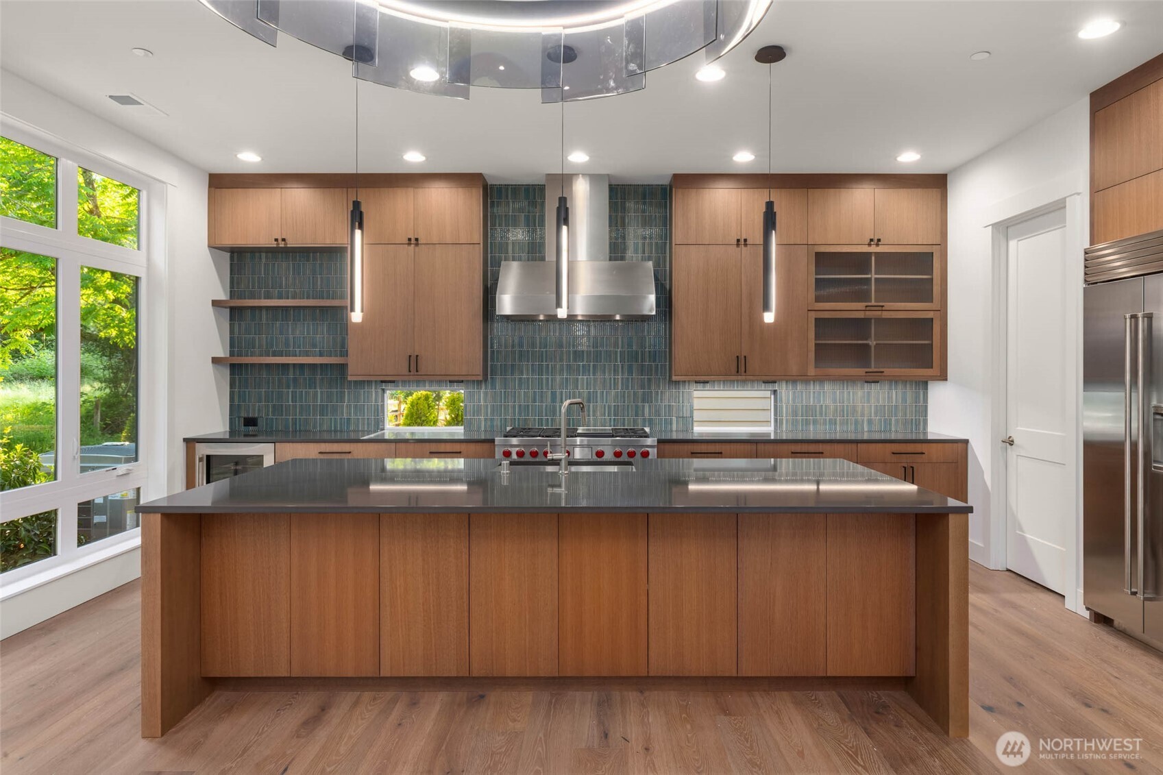 Custom designed full height cabinets with designer selected full height backspash, floating shelves