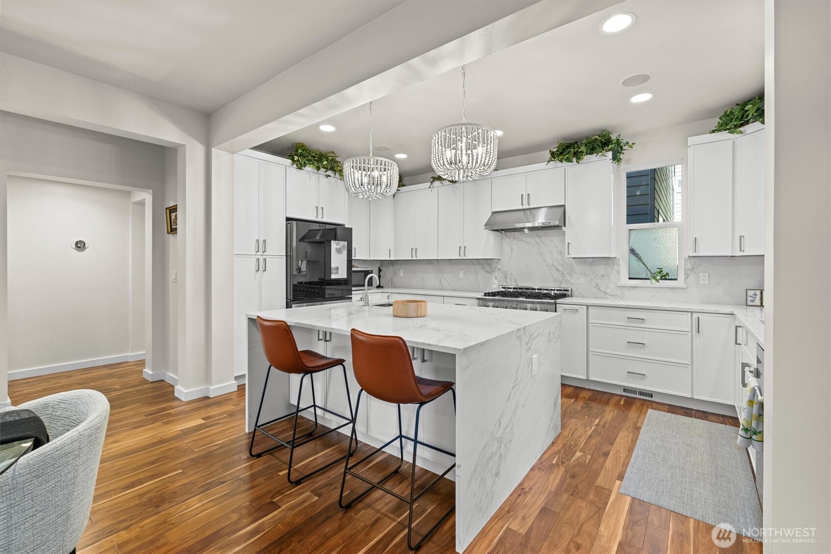 updated kitchen with quartz countertops, waterfall island, custom cabinetry, stainless steele appliances