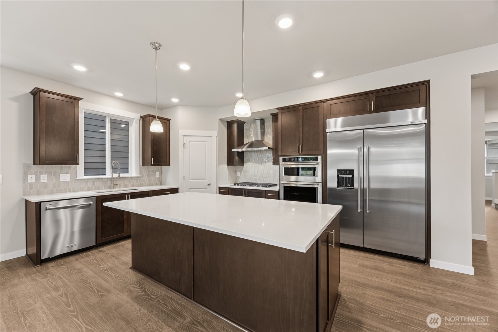 Gourmet kitchen with upgraded appliances including 48" built-in fridge, gas cooktop, standalone vent, wall oven and microwave. Photos are representational. Actual colors and finishes will vary. See site agent for details.