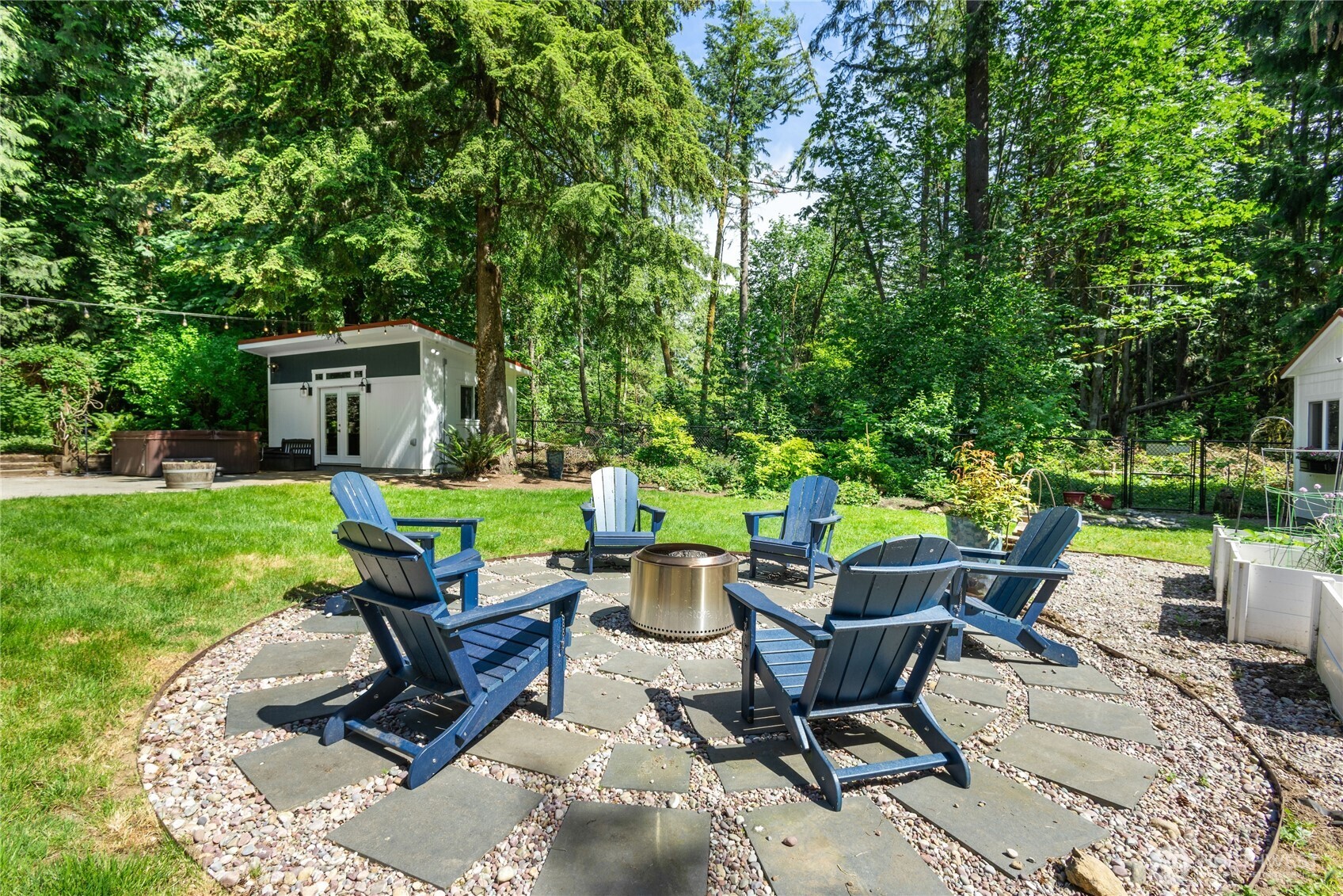 The circular fire pit patio comes complete with classic Adirondack seating and a premium Yukon Solo Stove—perfect for cozy evenings under the stars.