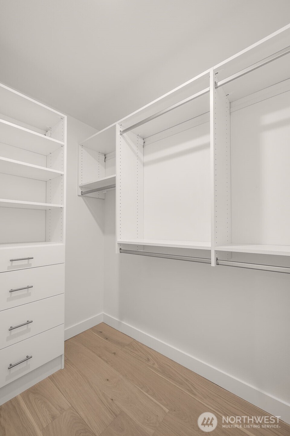 A custom walk-in closet with built-in shelving and hanging storage makes staying organized a breeze in the primary suite.