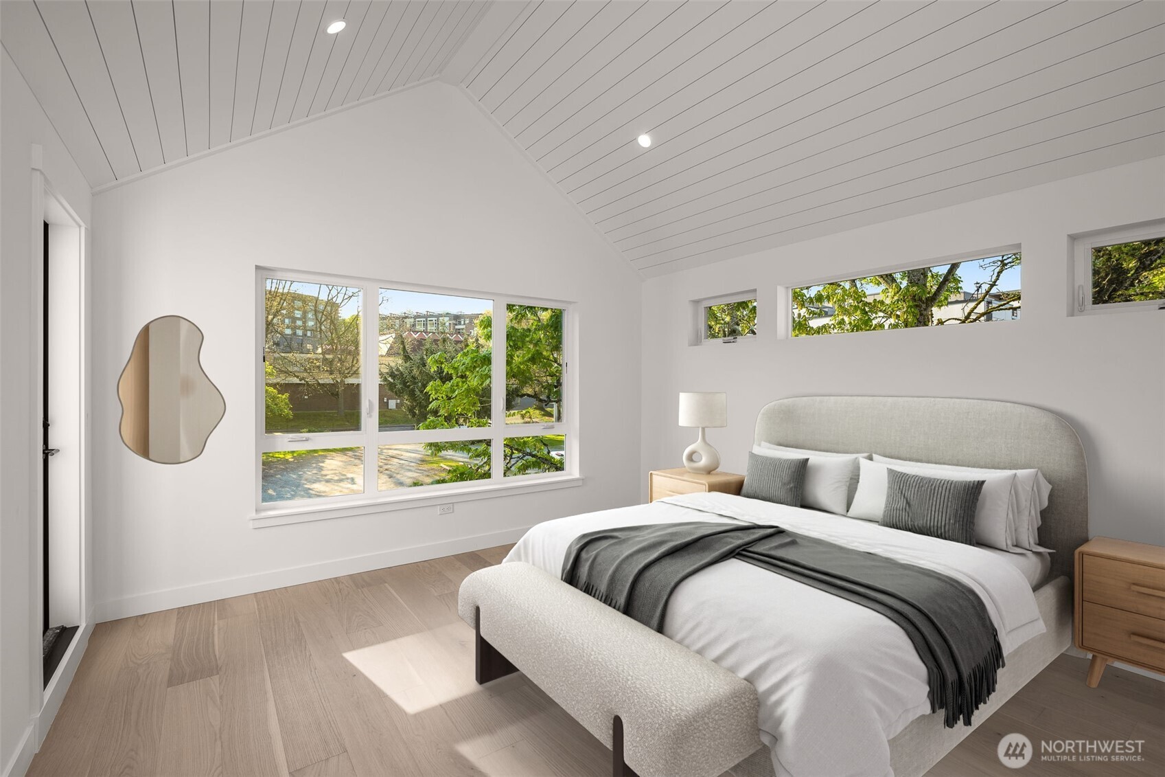 This photo is virtually staged. Vaulted ceilings and horizontal windows draw your eyes upward, creating a serene and airy retreat in the upper-level bedroom.