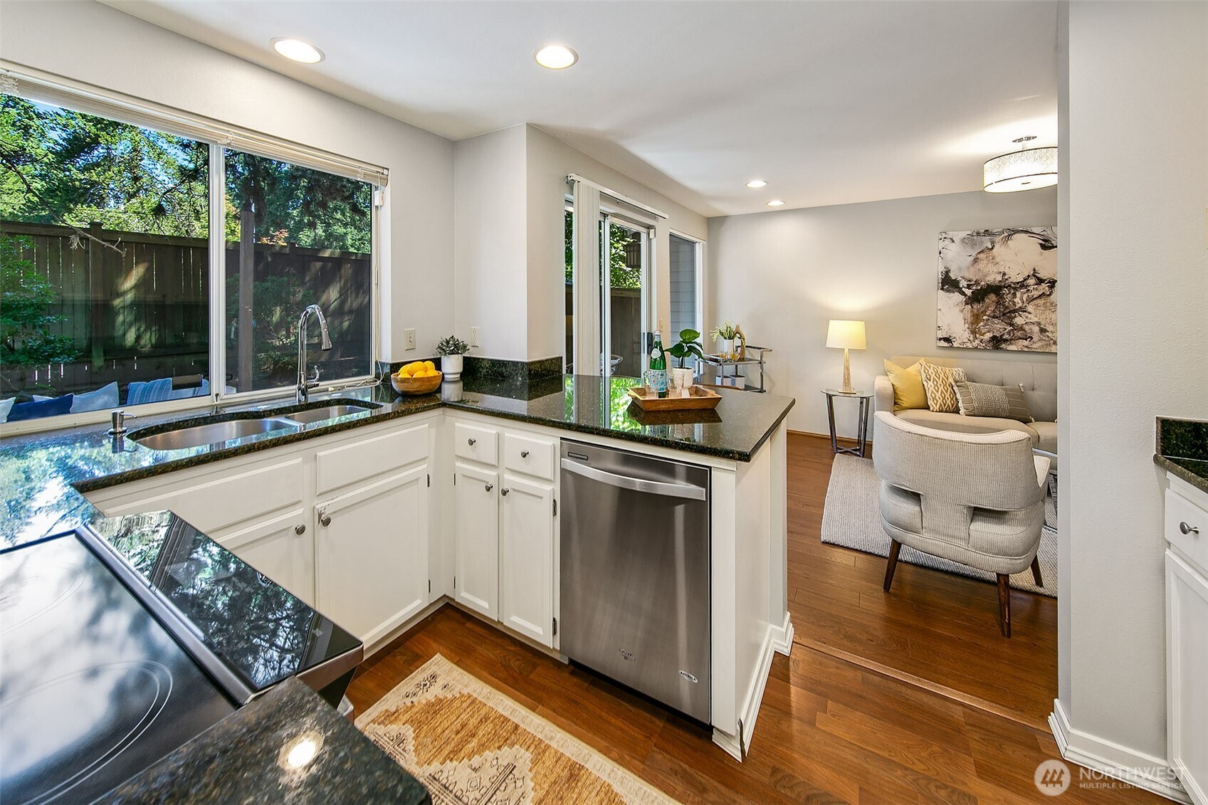 Kitchen, with plenty of storage and a new induction range, is open to the informal living room.