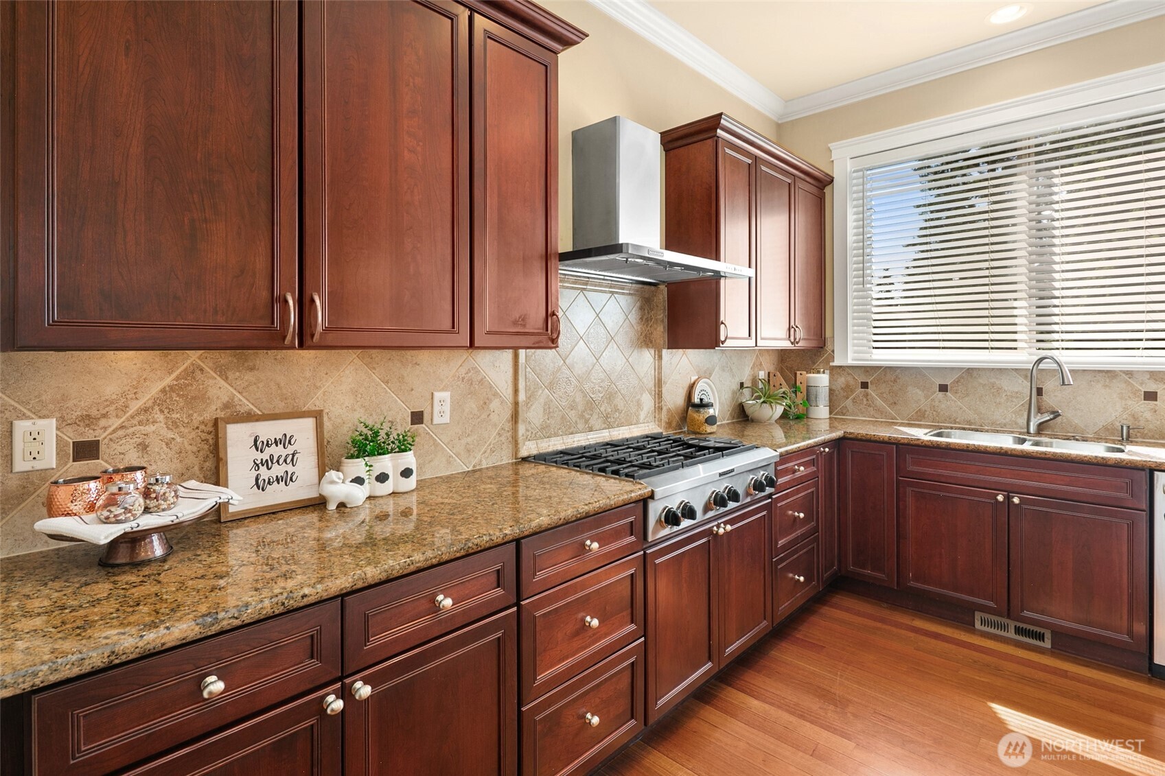 Dream kitchen boasts high-end appliances, including a Bosch refrigerator and dishwasher. Features include a stylish tiled backsplash, glass pantry door, spacious central island with cabinetry, slab granite countertops, and an elegant breakfast nook that flows from the family room to the outdoor retreat. Abundant natural light completes the space.