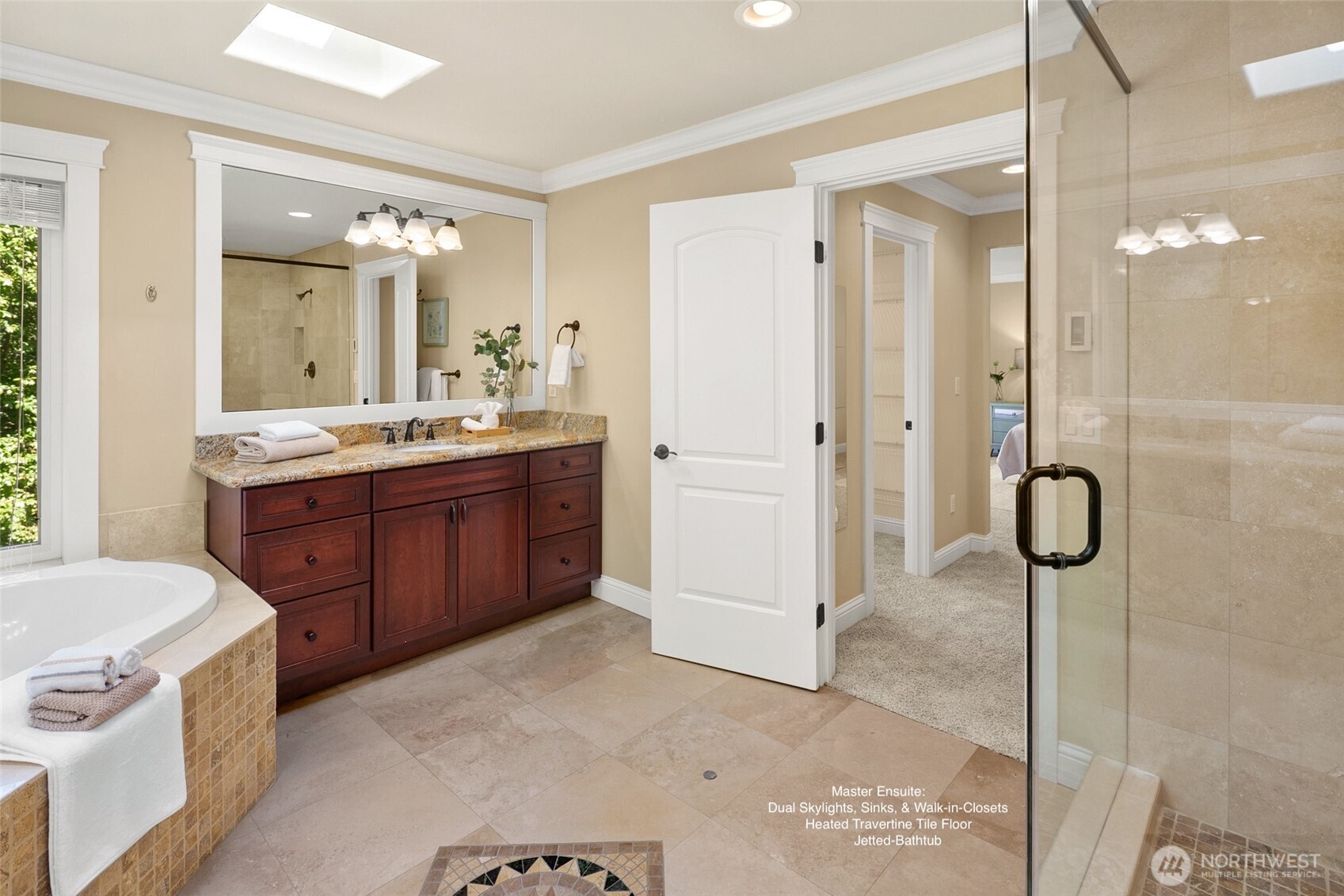 Luxurious master spa bath features an extra-large jetted tub and tiled shower, heated travertine floor, two skylights.