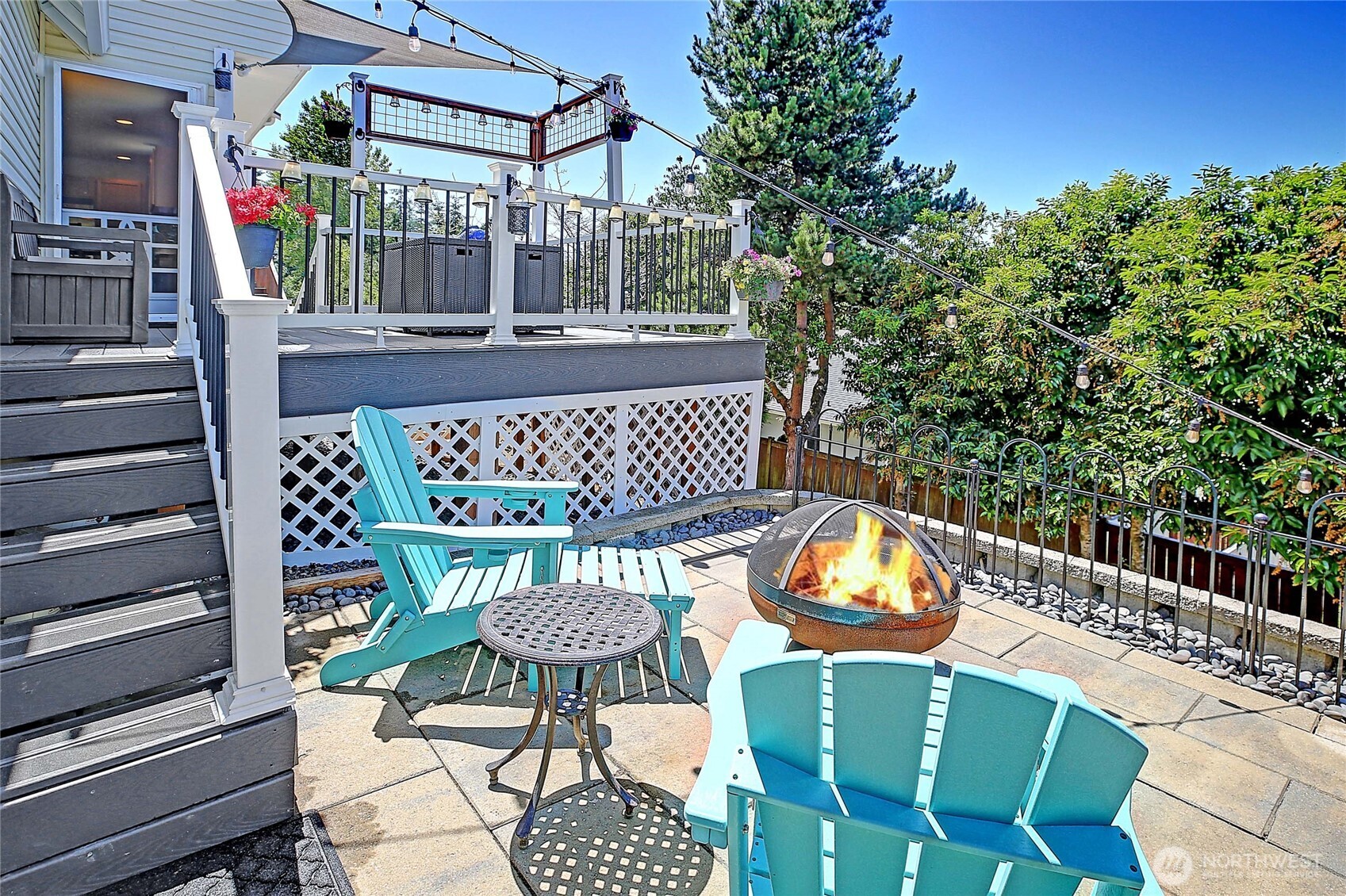 View of patio area NW side of home with stairs to deck.